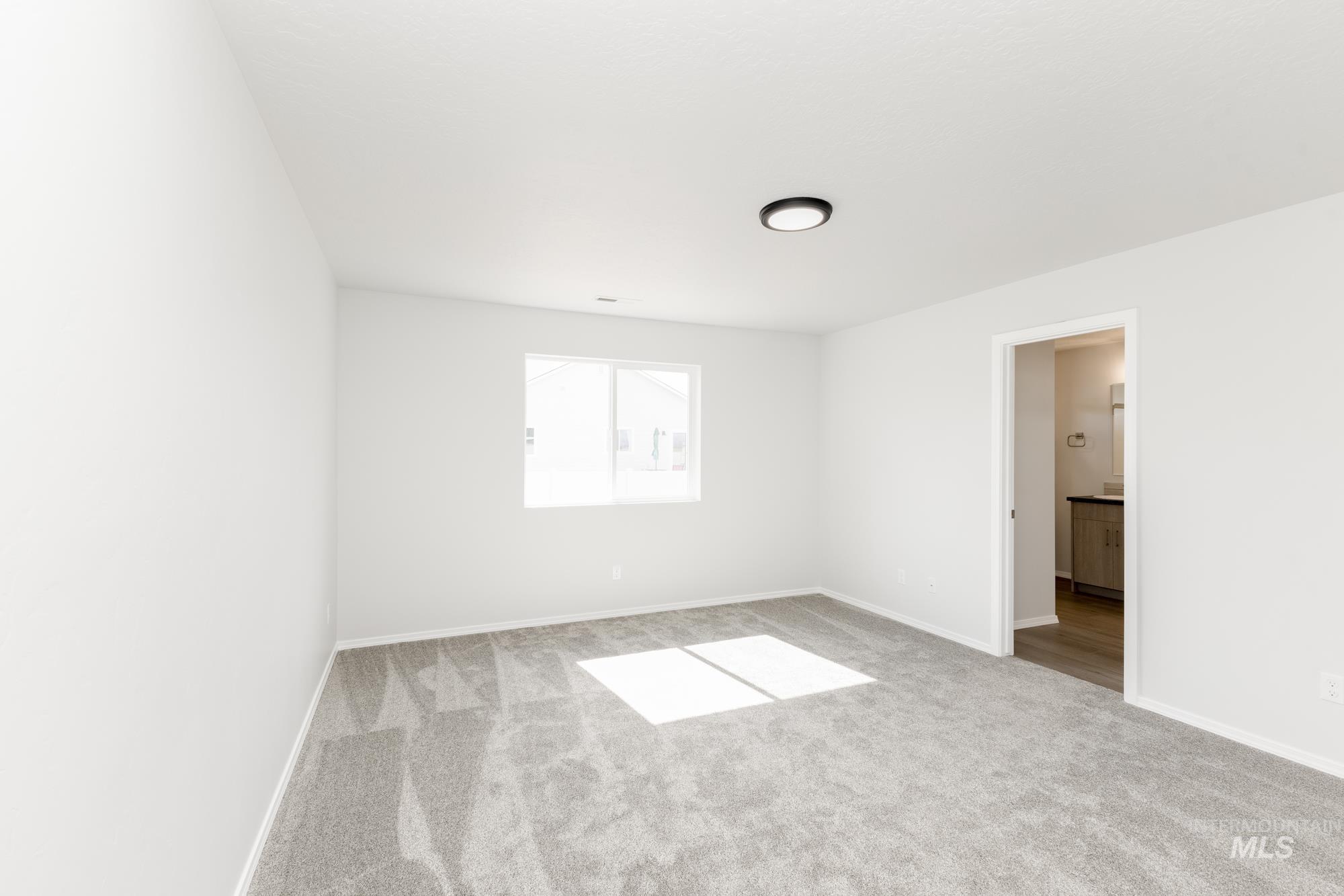 Unfurnished room with light colored carpet and baseboards