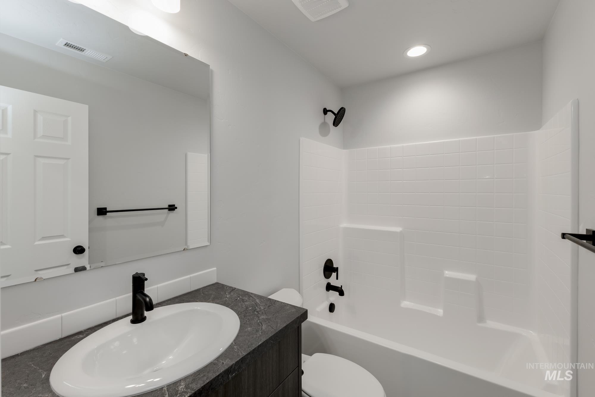 Full bathroom featuring vanity, shower / tub combination, and recessed lighting