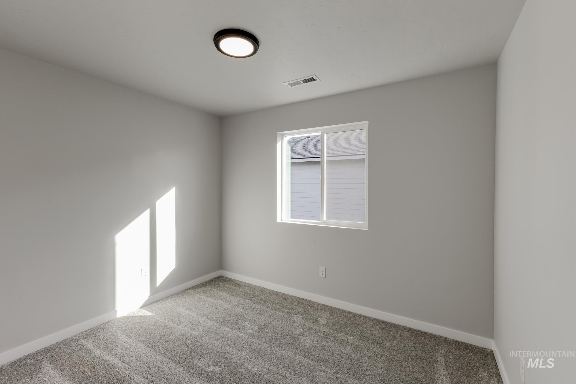 Carpeted empty room featuring baseboards
