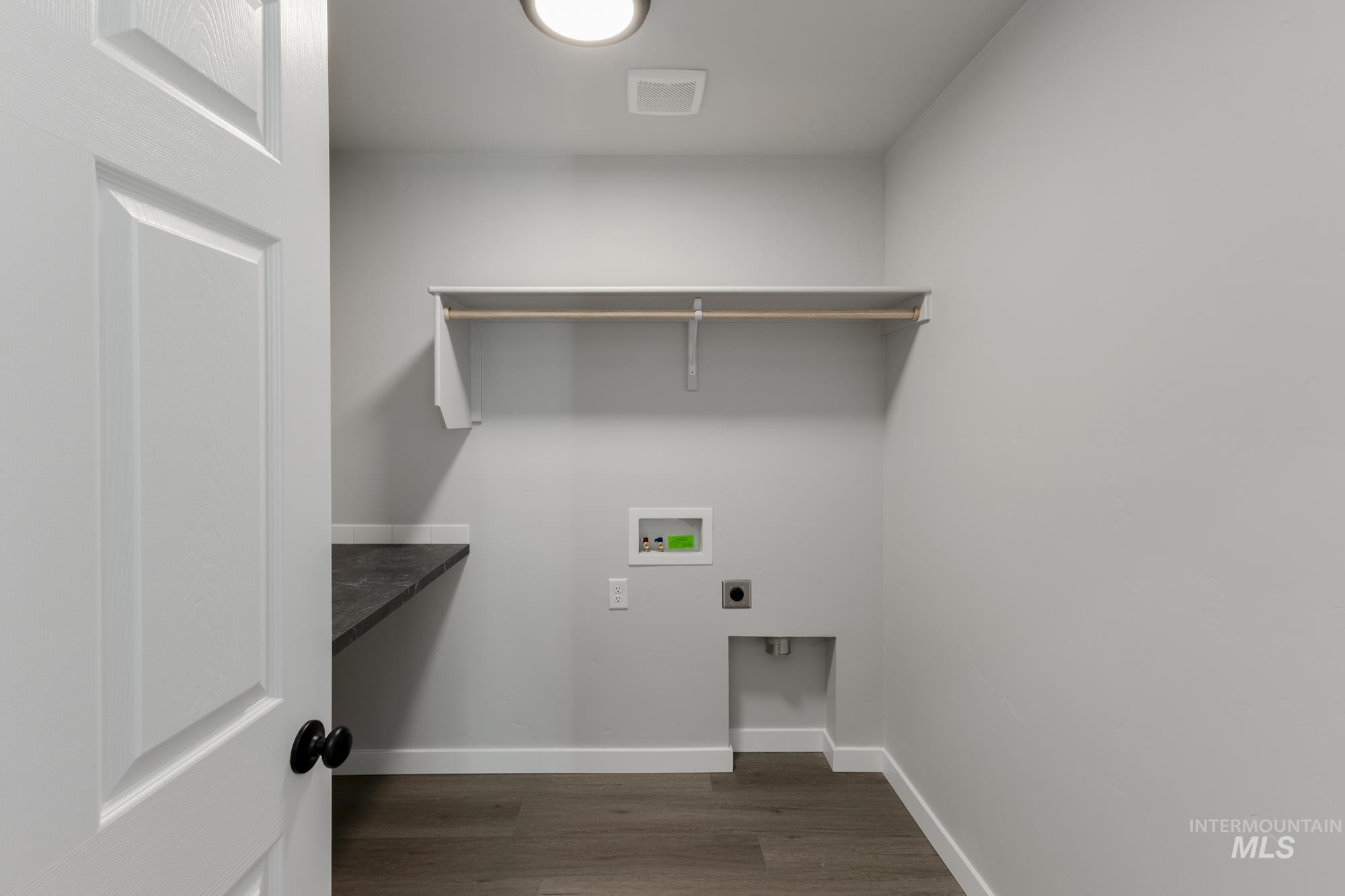Laundry area with dark wood finished floors, washer hookup, and hookup for an electric dryer