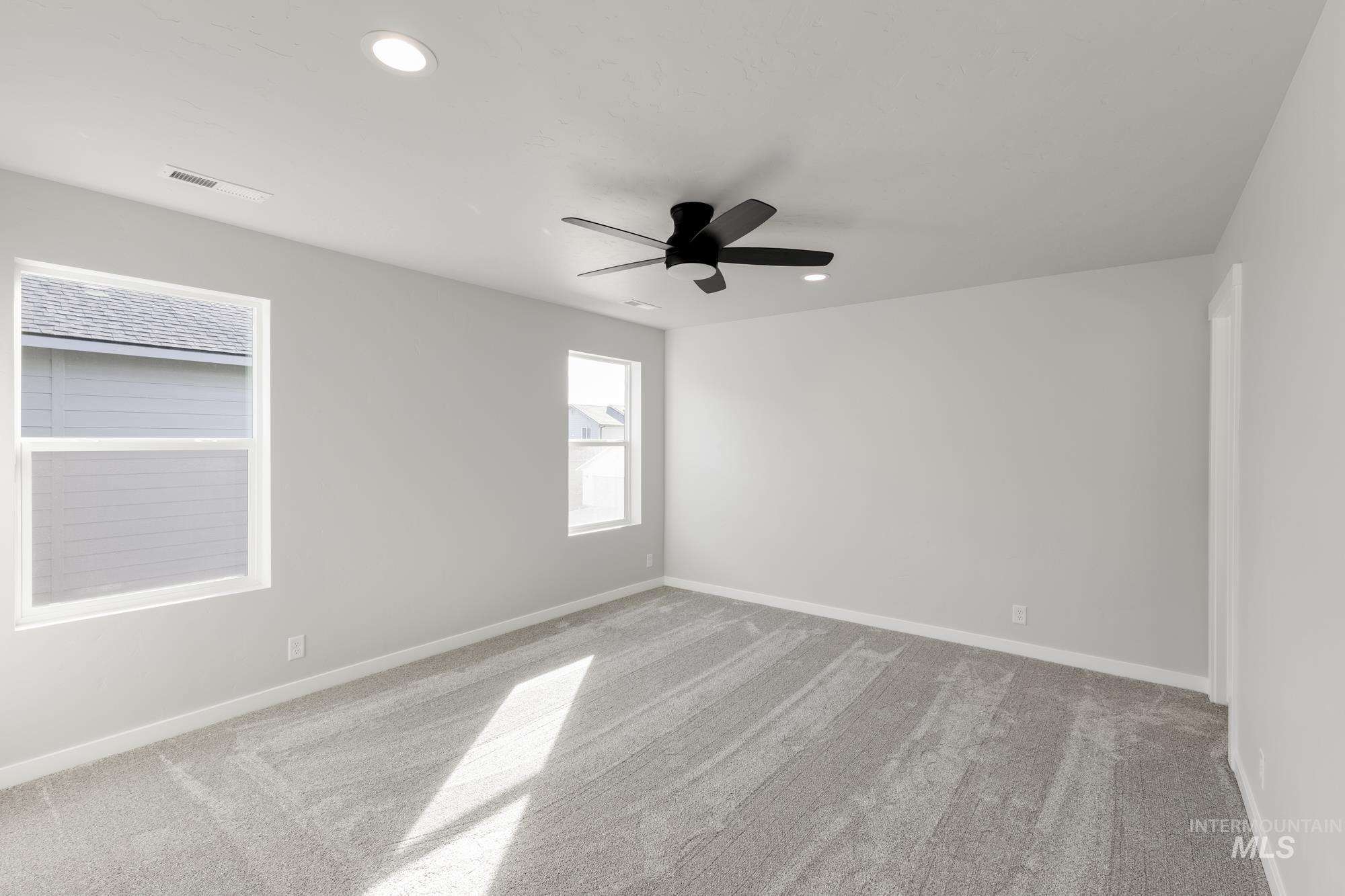 Spare room featuring light colored carpet, recessed lighting, and ceiling fan