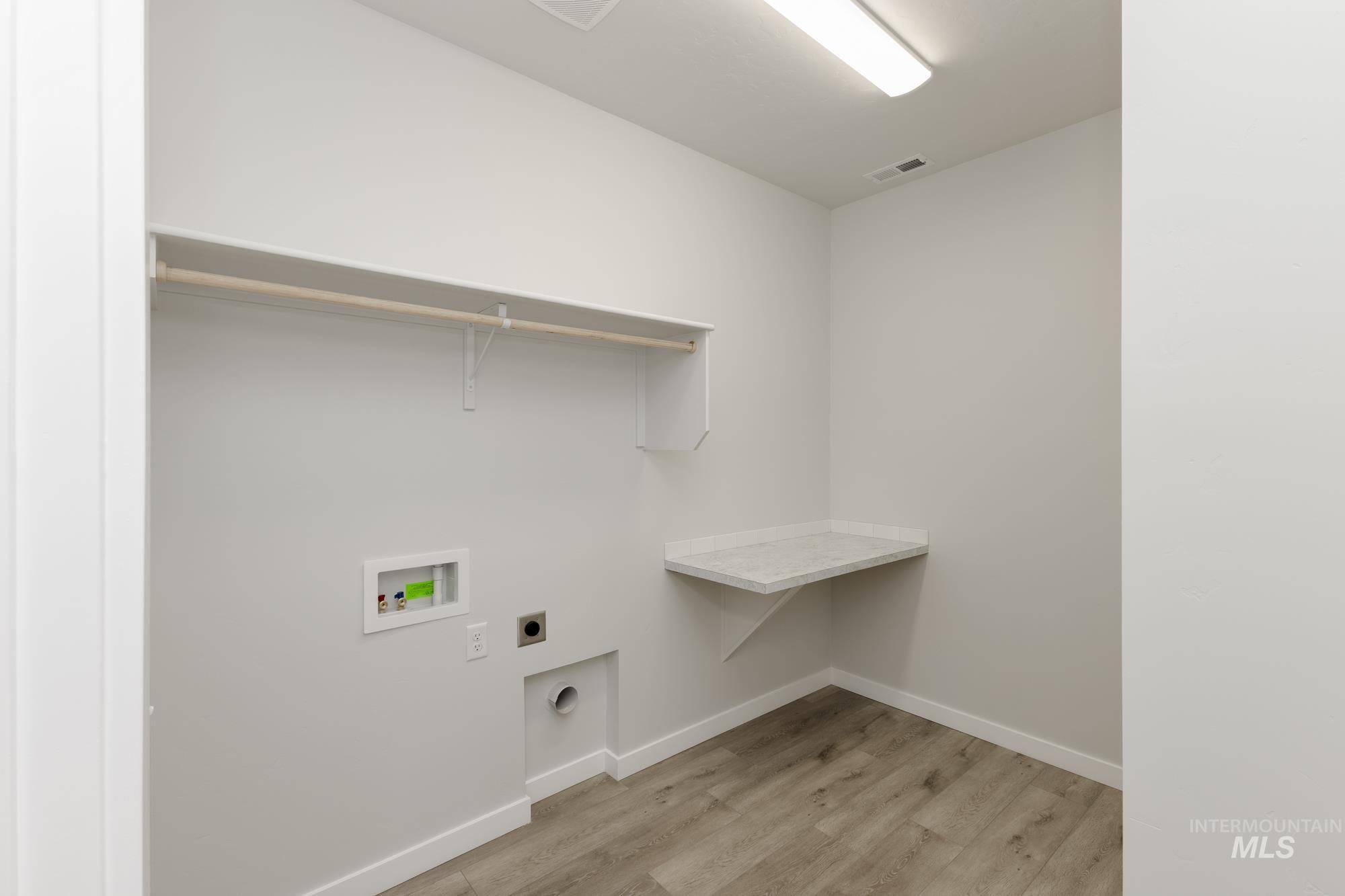Laundry area featuring hookup for an electric dryer, light wood finished floors, and washer hookup