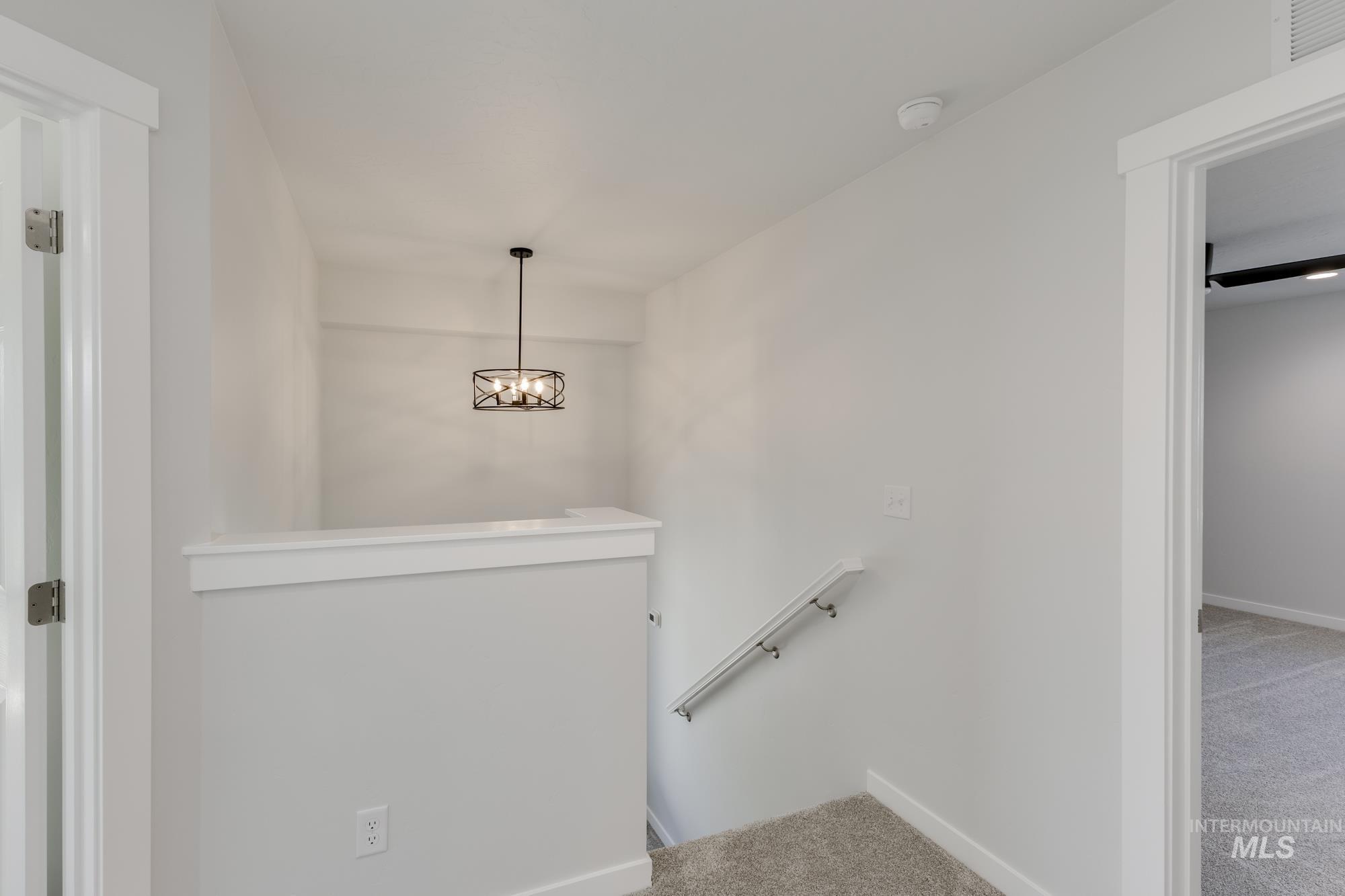 Stairs featuring carpet flooring and a chandelier
