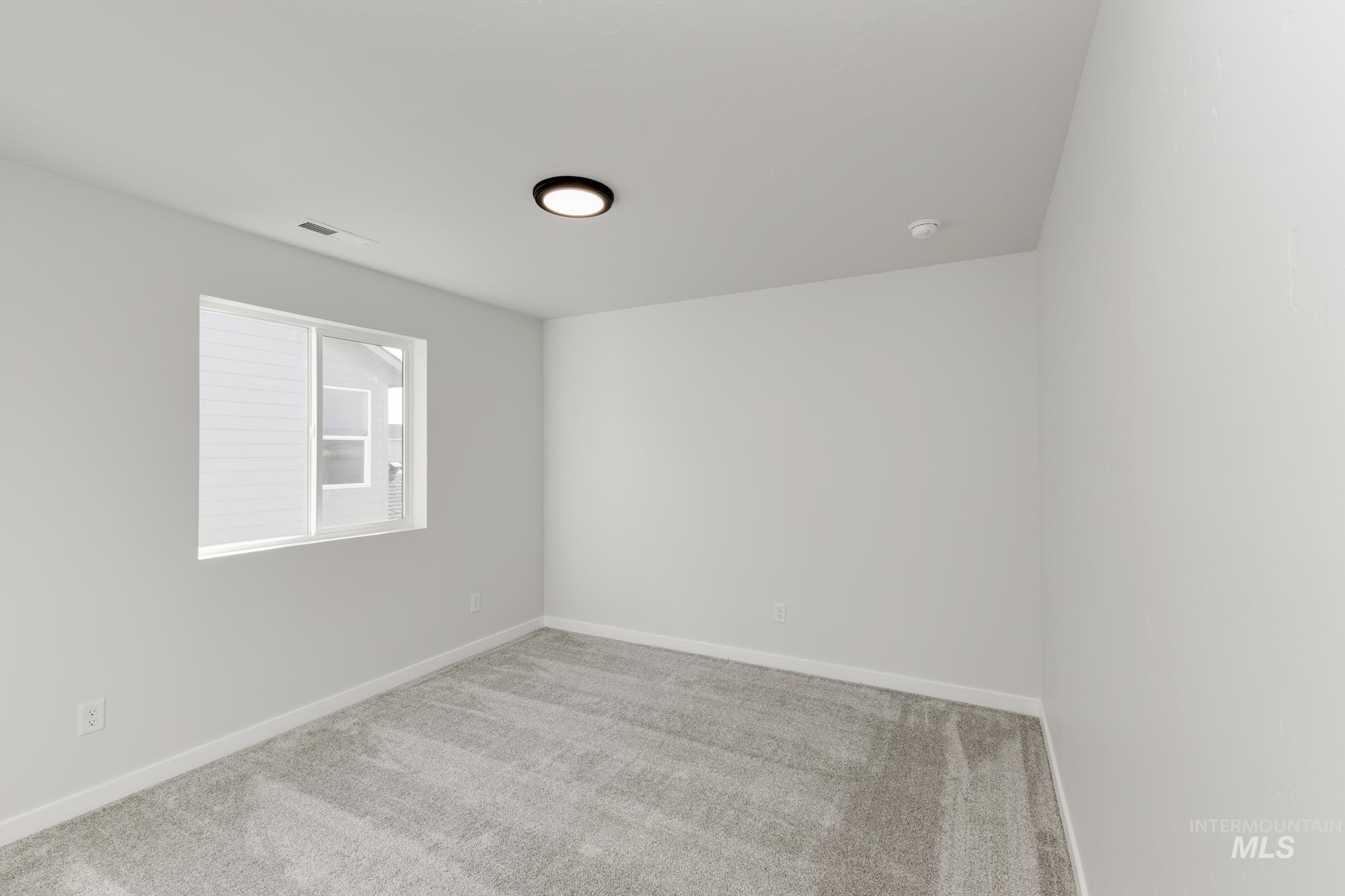 Carpeted empty room with baseboards