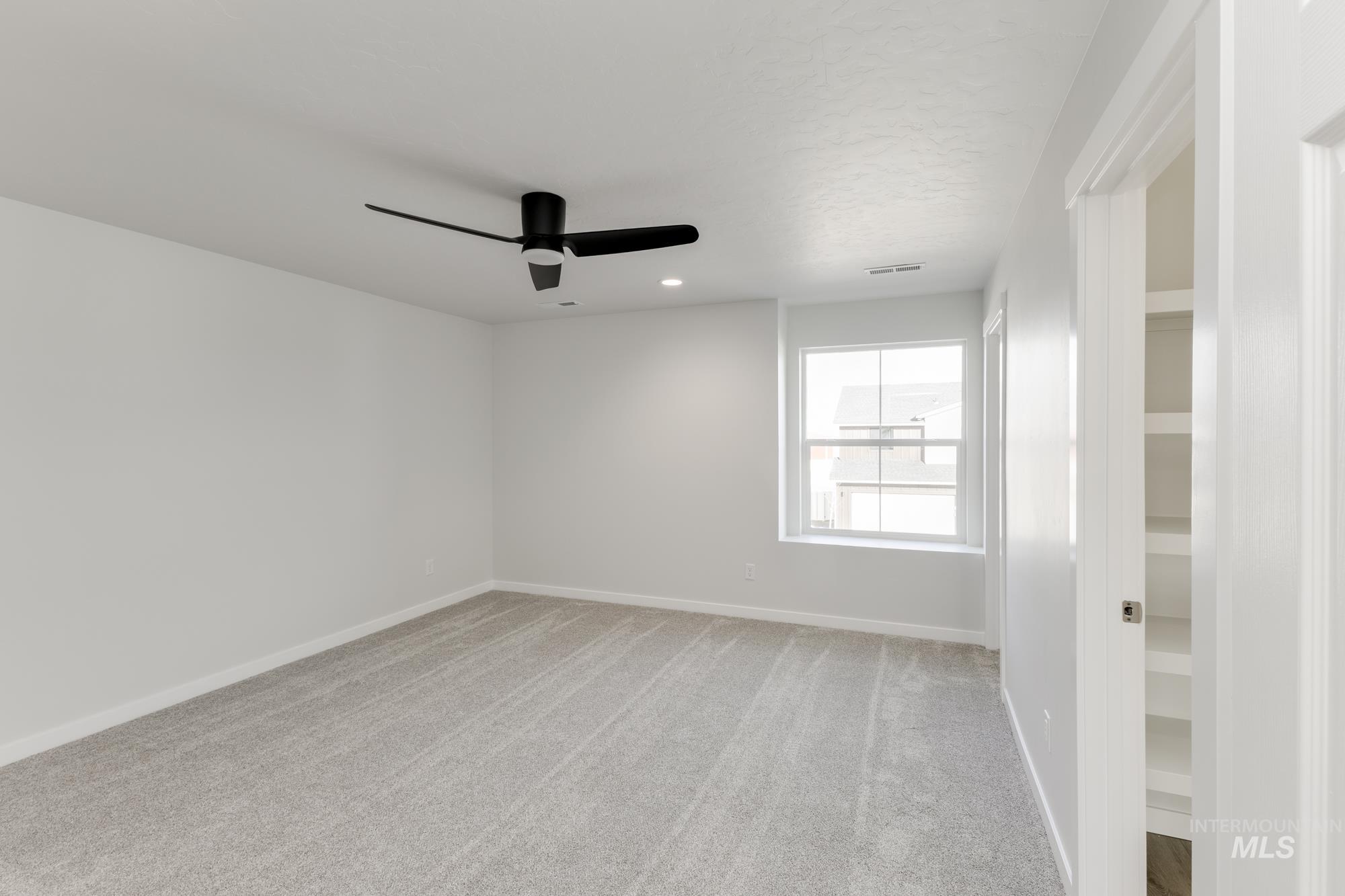 Empty room featuring light carpet and ceiling fan