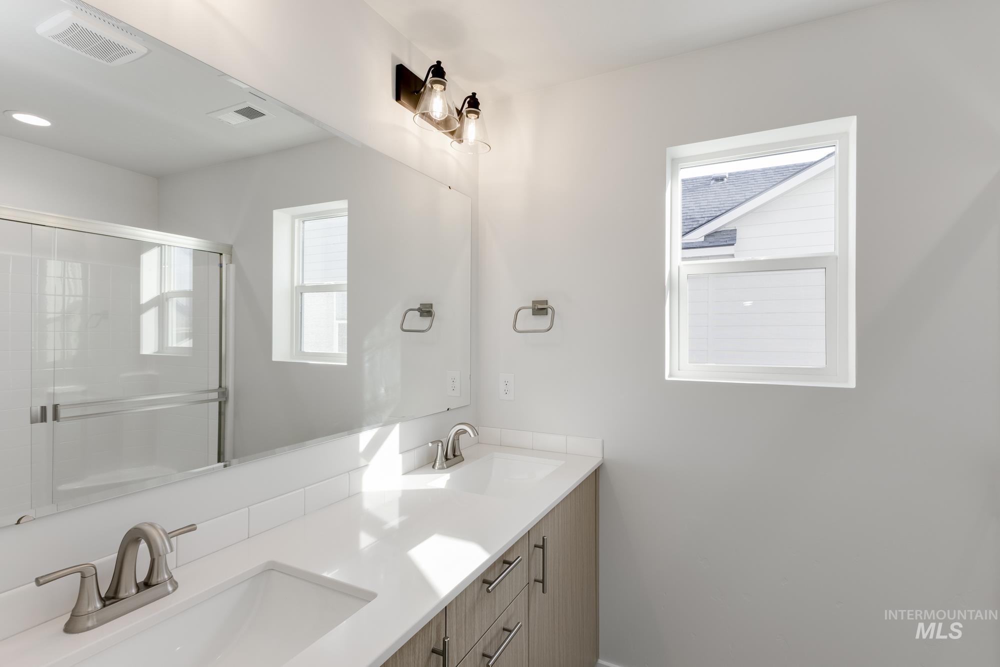 Bathroom with double vanity and a shower stall