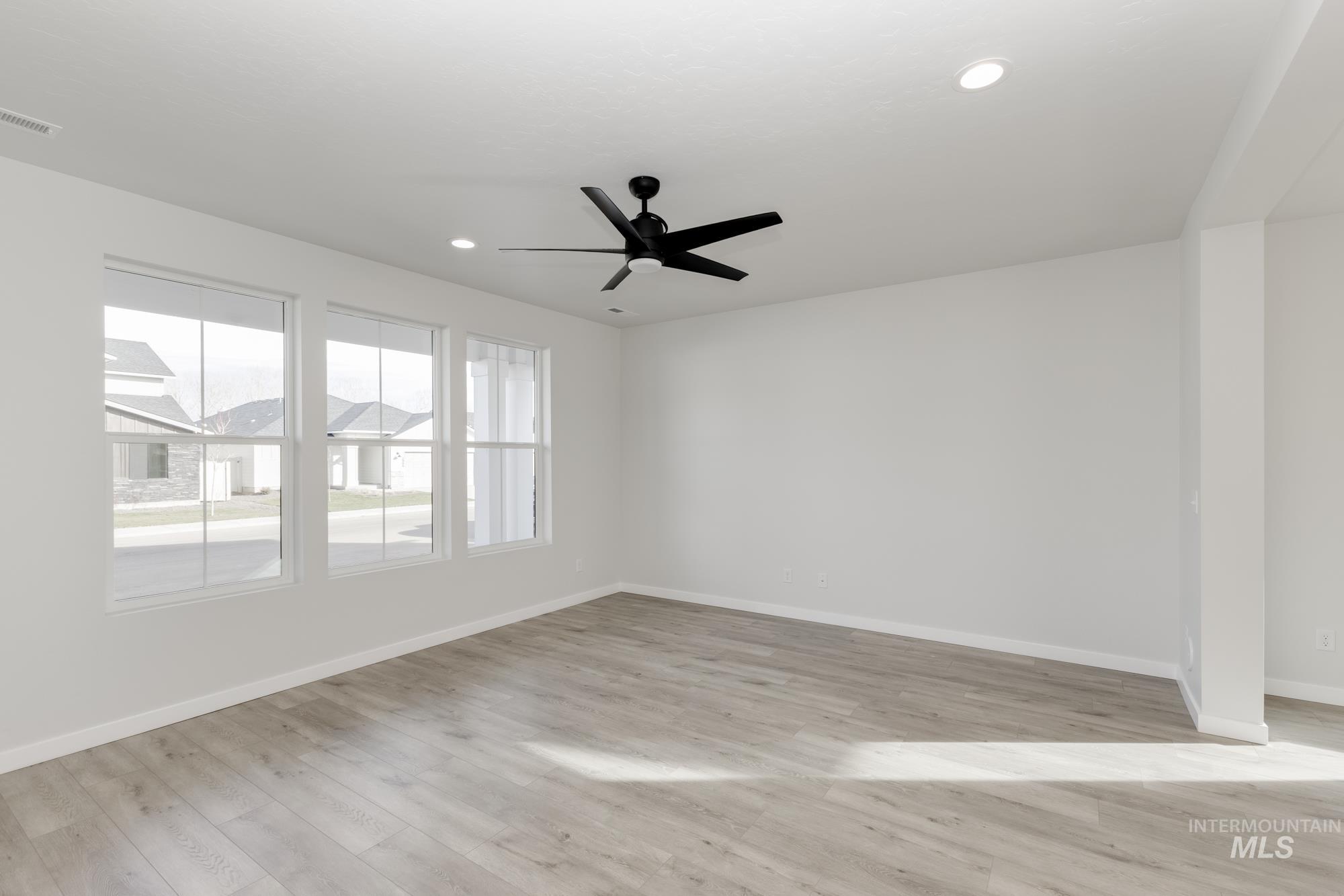 Spare room with light wood-type flooring, a ceiling fan, and recessed lighting