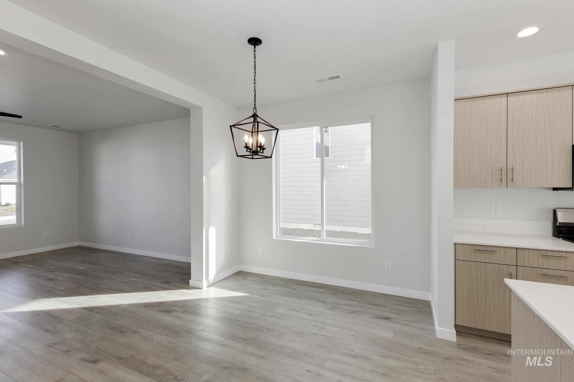 Unfurnished dining area featuring recessed lighting, light wood-type flooring, and a chandelier
