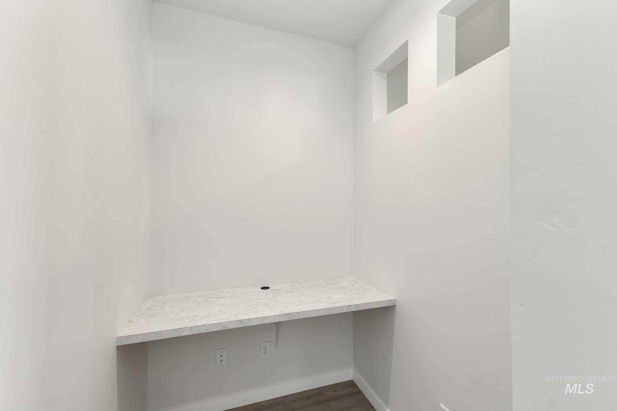 Unfurnished office with dark wood finished floors and baseboards