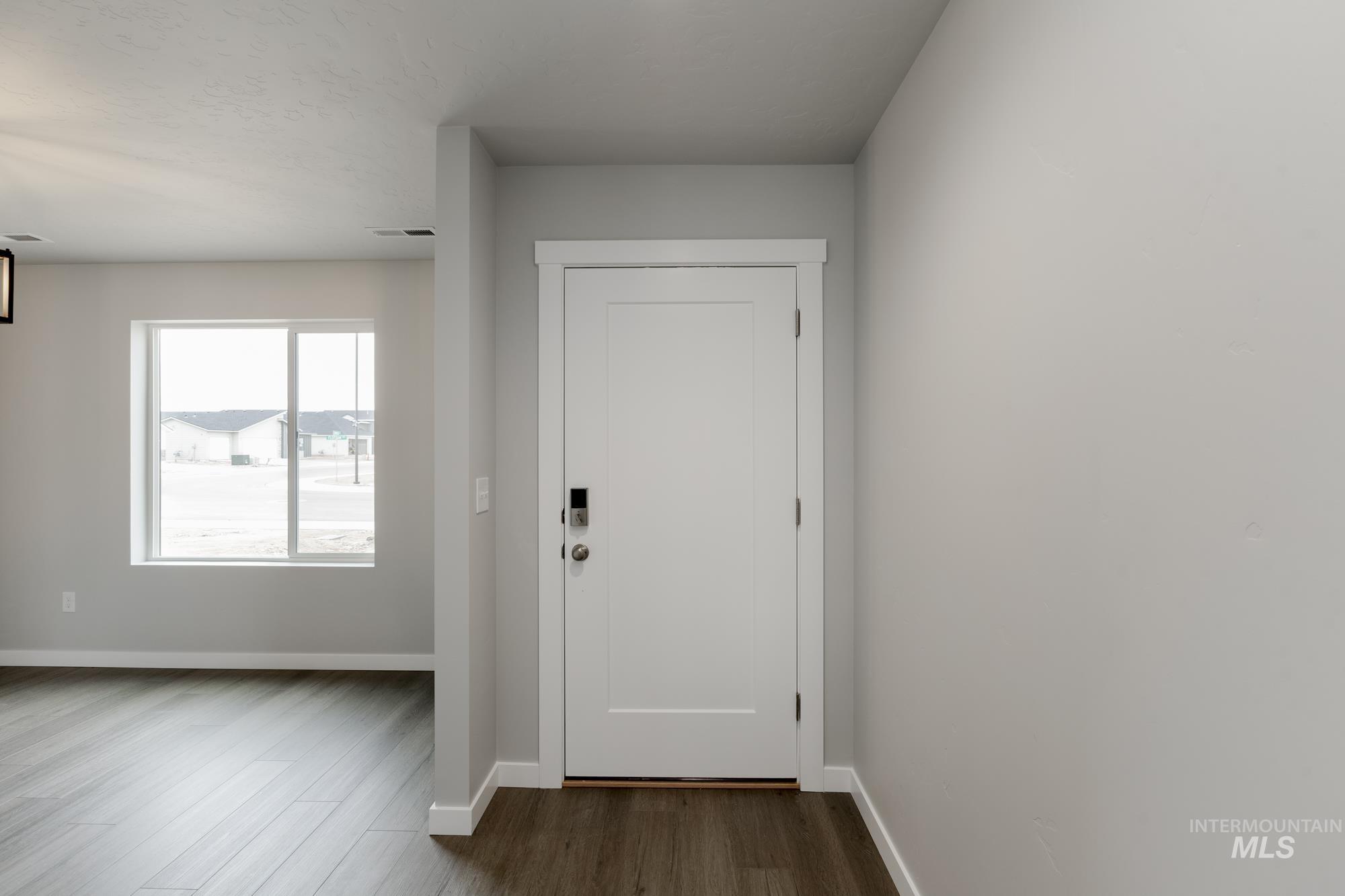 Doorway to outside with baseboards and wood finished floors