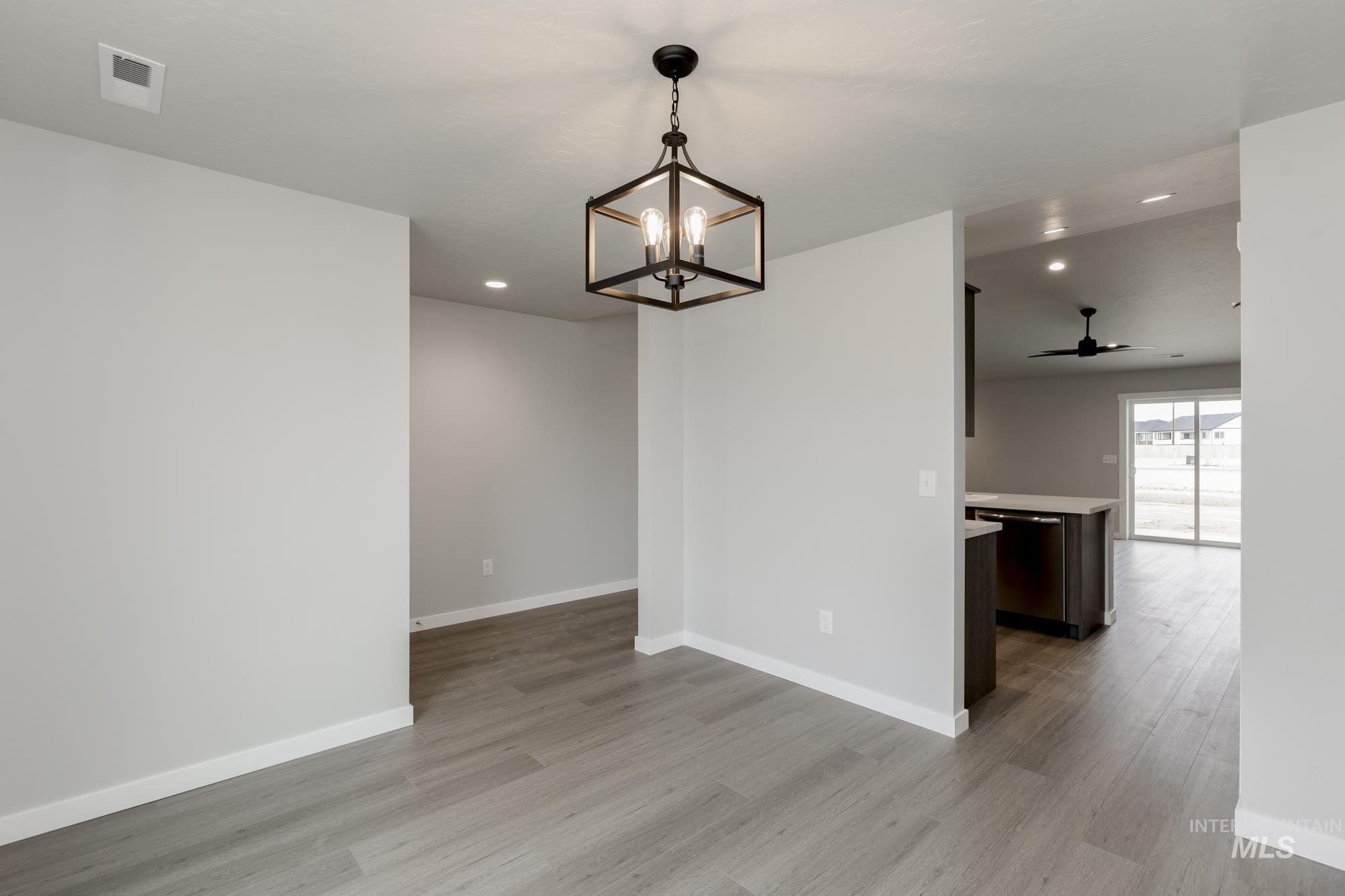 Empty room with recessed lighting, ceiling fan, light wood finished floors, and a chandelier