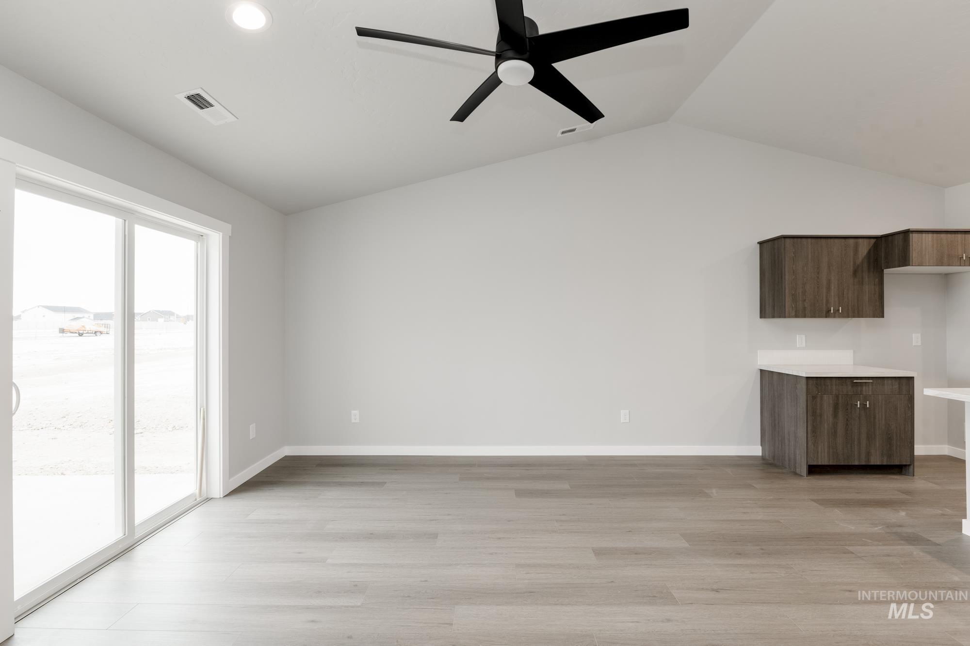Unfurnished living room with light wood-style flooring, lofted ceiling, a ceiling fan, and recessed lighting