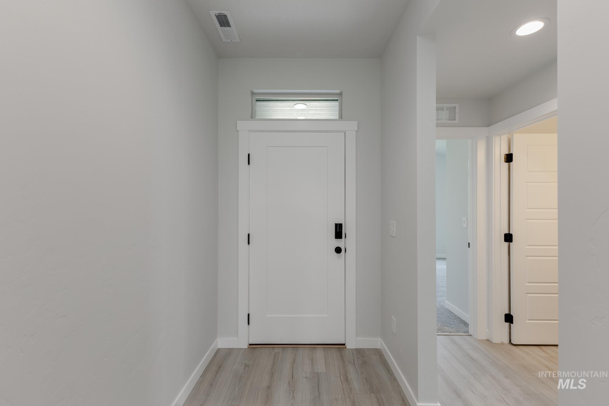 Entryway featuring light wood-style flooring and recessed lighting