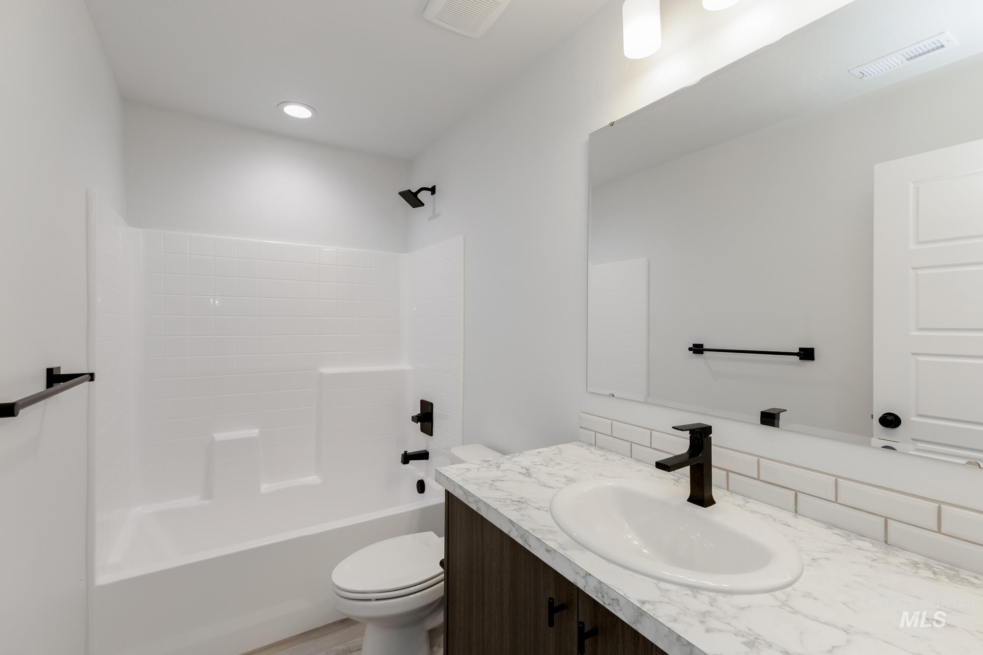 Bathroom with  shower combination, vanity, and recessed lighting