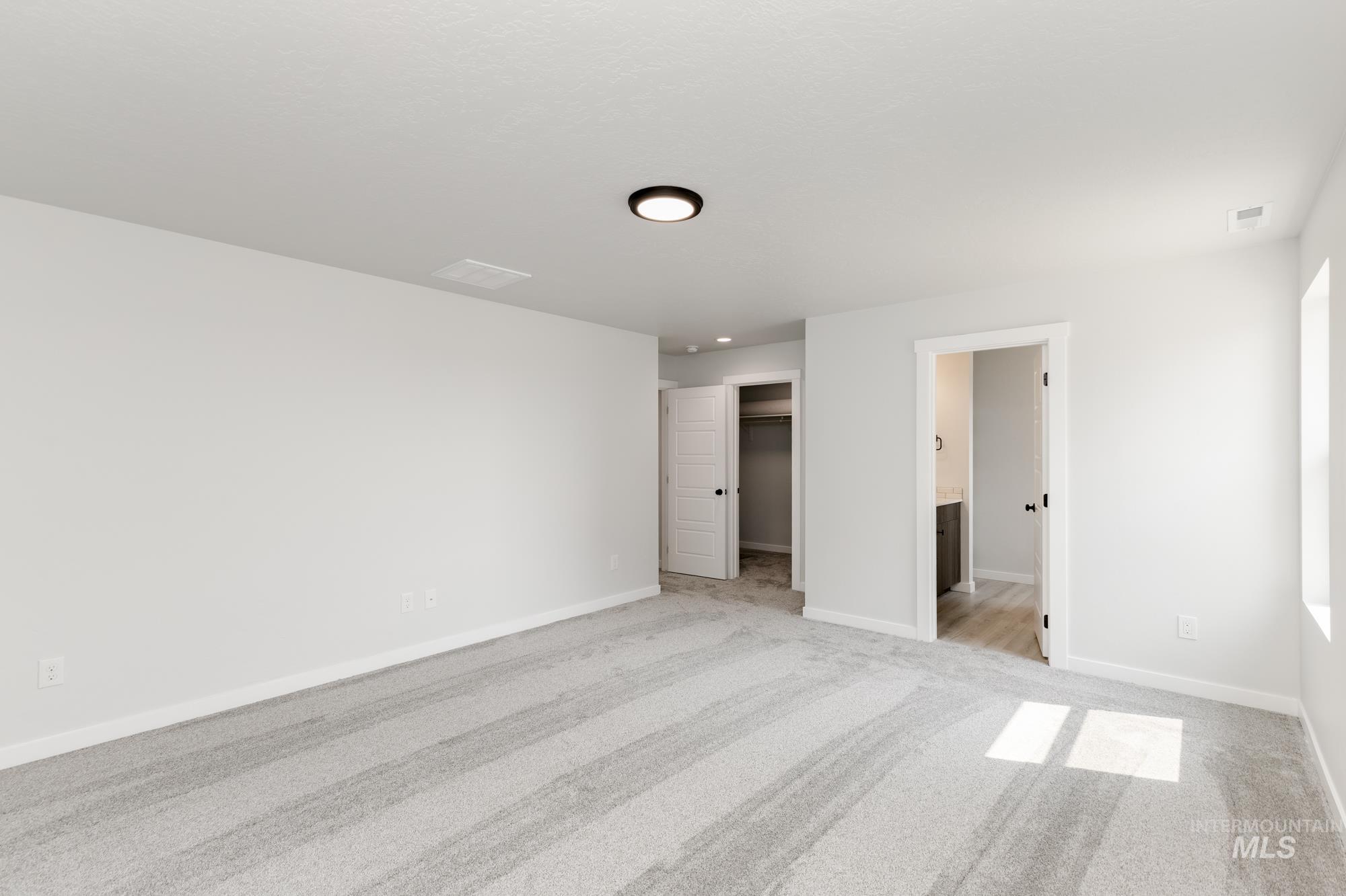 Unfurnished bedroom featuring a spacious closet and light colored carpet