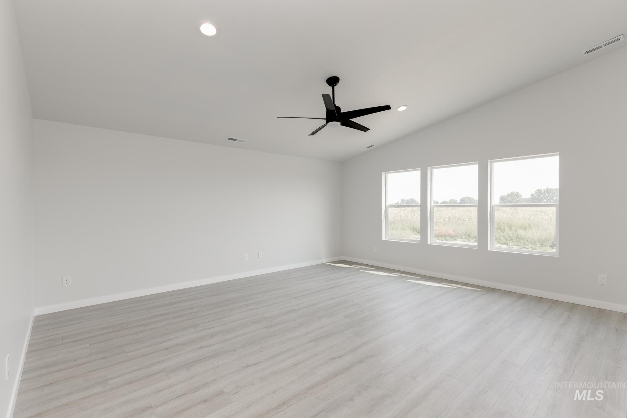 Unfurnished room with light wood finished floors, lofted ceiling, recessed lighting, and a ceiling fan