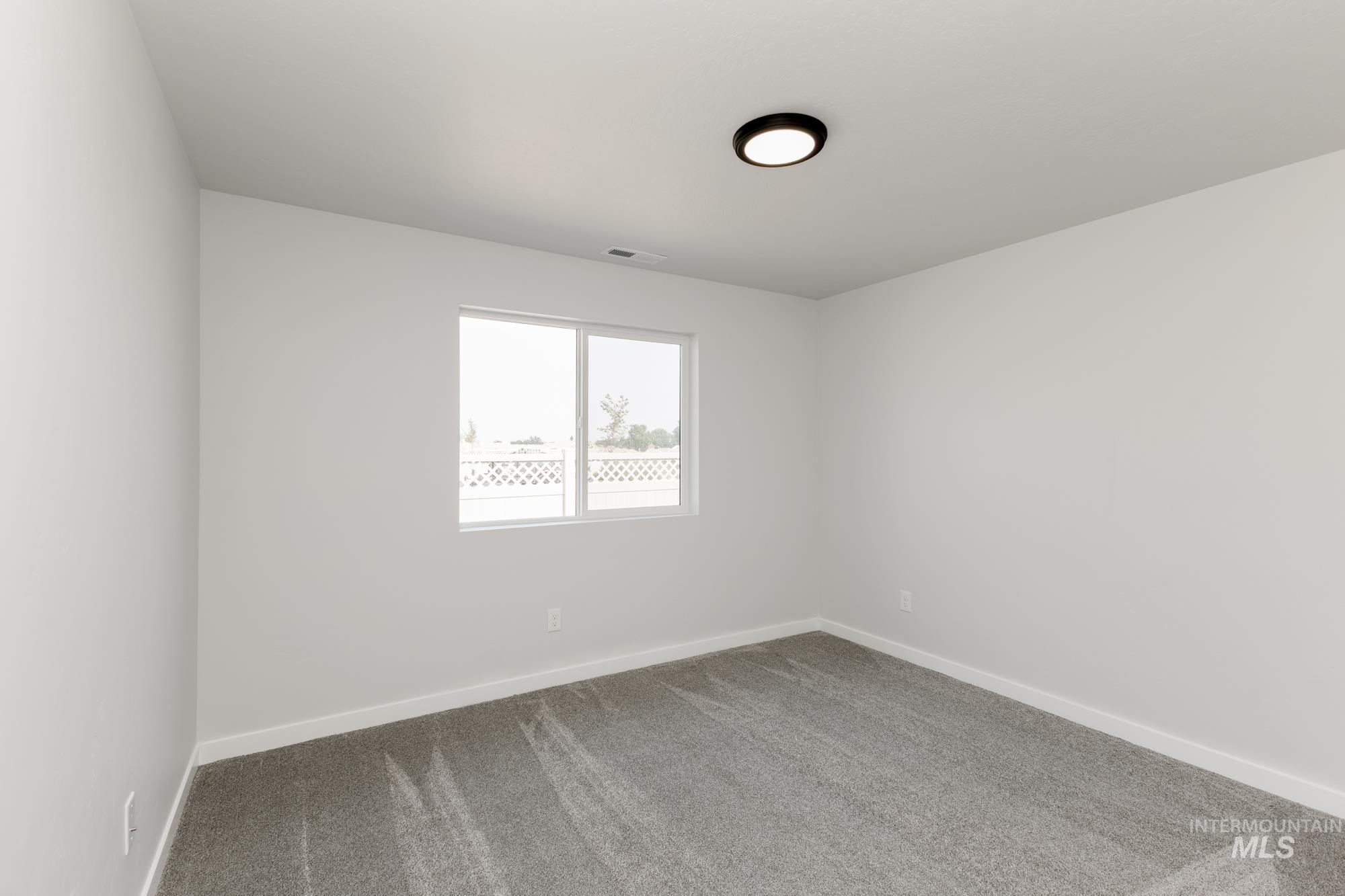 Empty room featuring carpet and baseboards