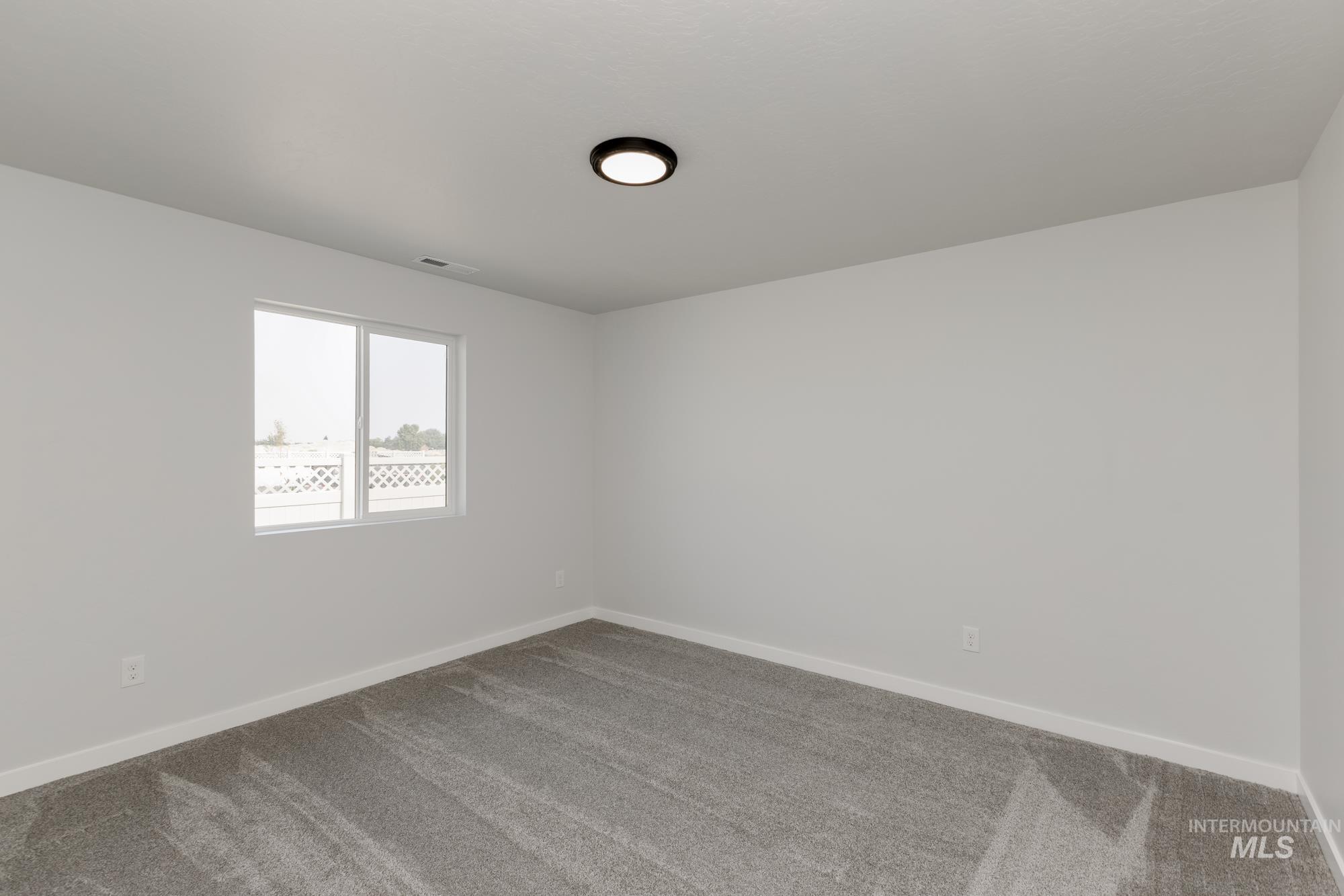 Carpeted empty room with baseboards