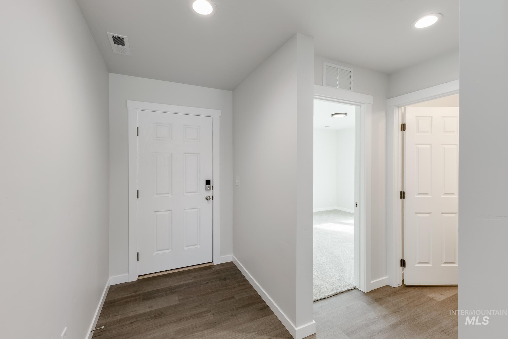 Corridor with wood finished floors and recessed lighting