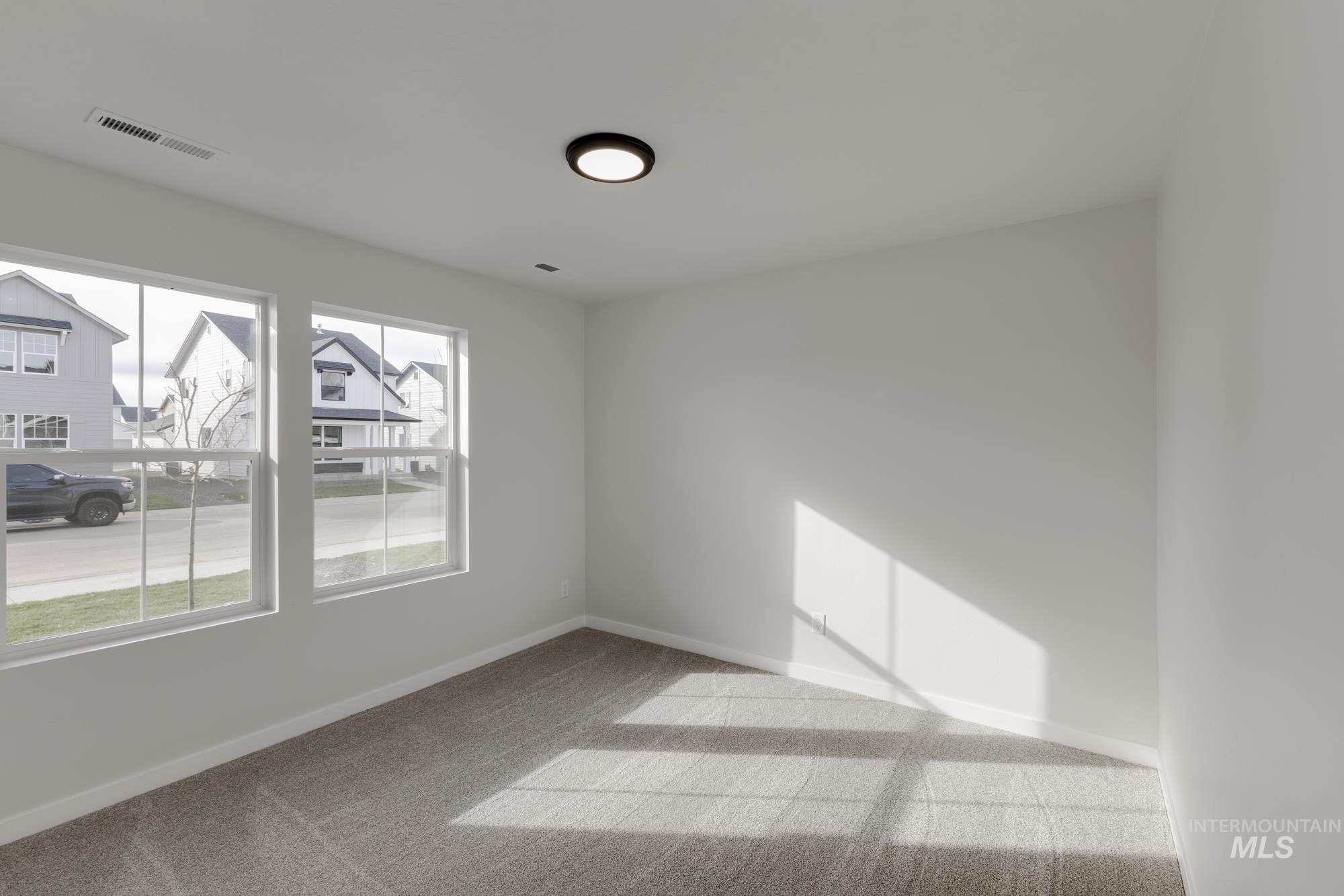 Unfurnished room with baseboards and light carpet