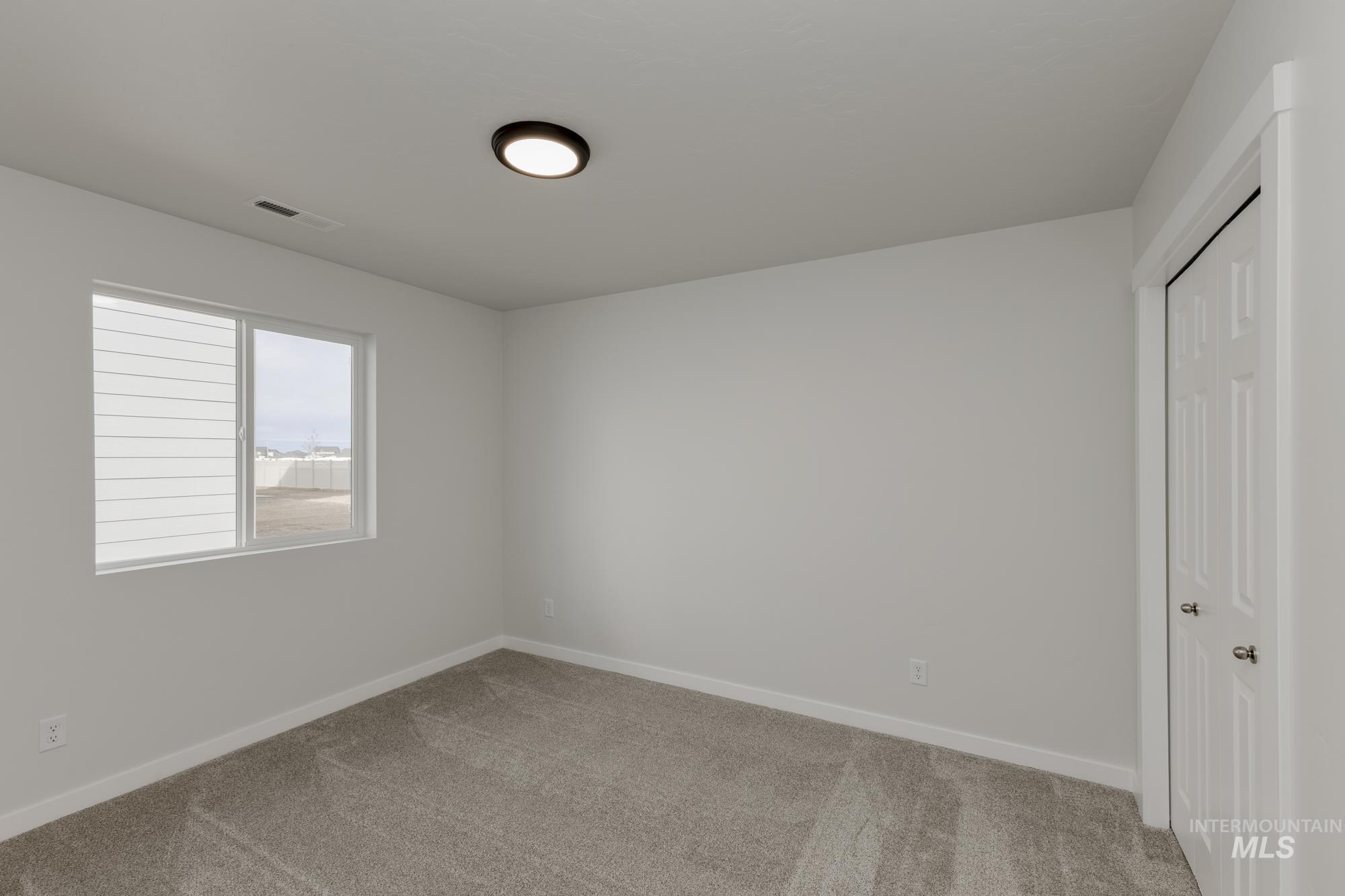Unfurnished bedroom featuring a closet and light colored carpet