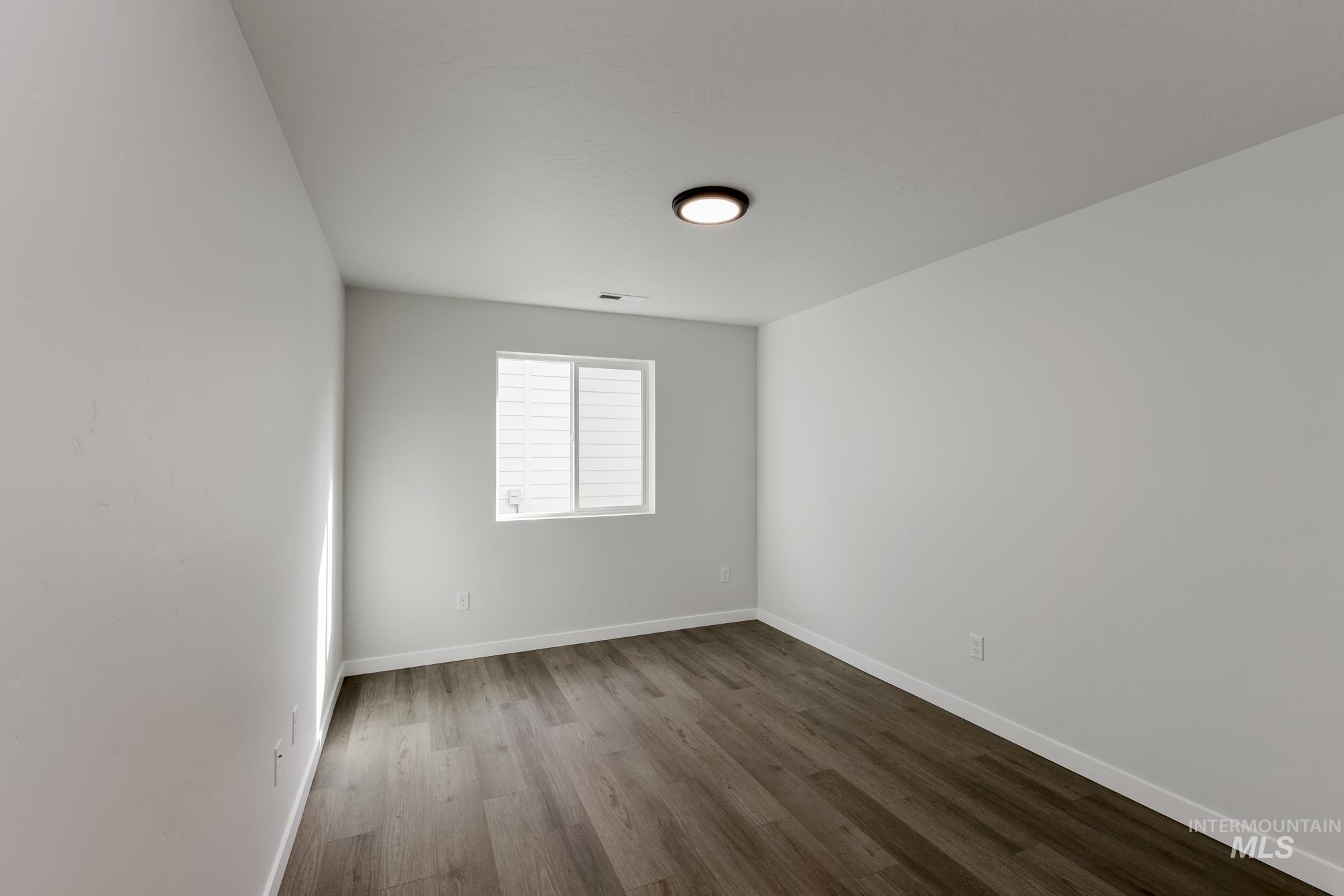 Unfurnished room with wood finished floors and baseboards