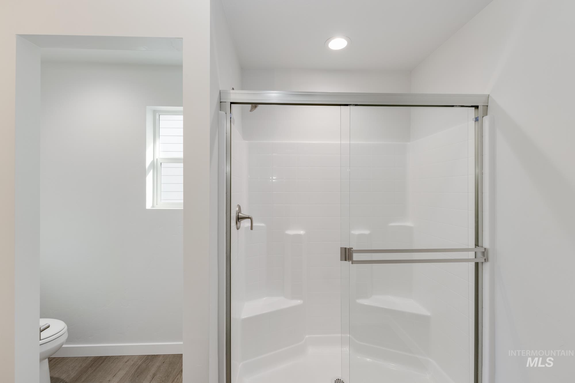 Bathroom featuring a shower stall and light wood finished floors