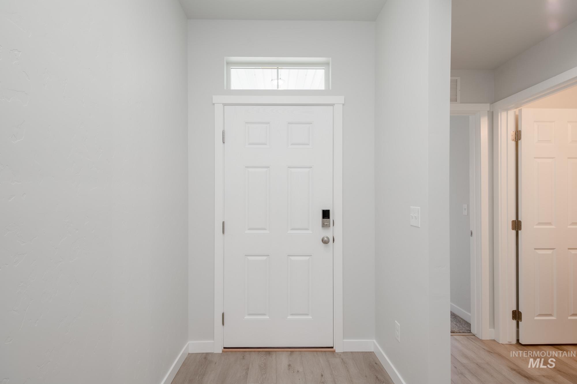 Doorway featuring wood finished floors and baseboards