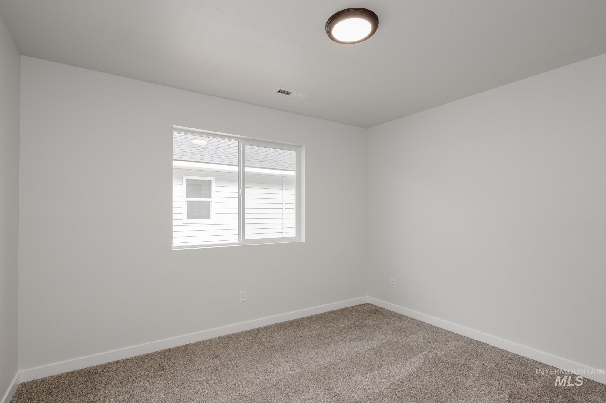 Empty room with carpet flooring and baseboards