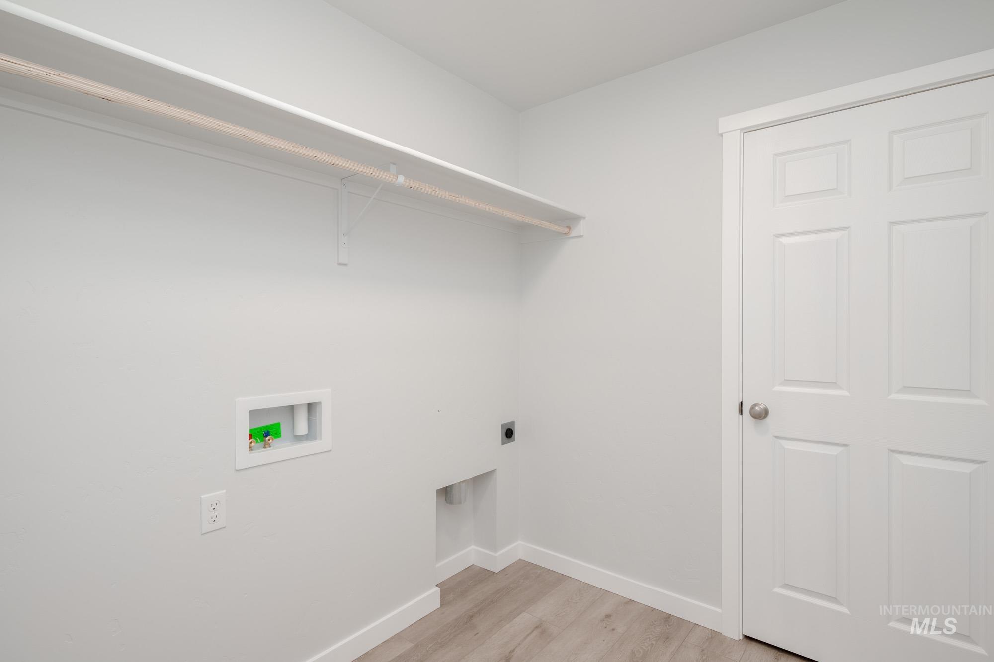 Washroom with light wood finished floors, electric dryer hookup, and washer hookup