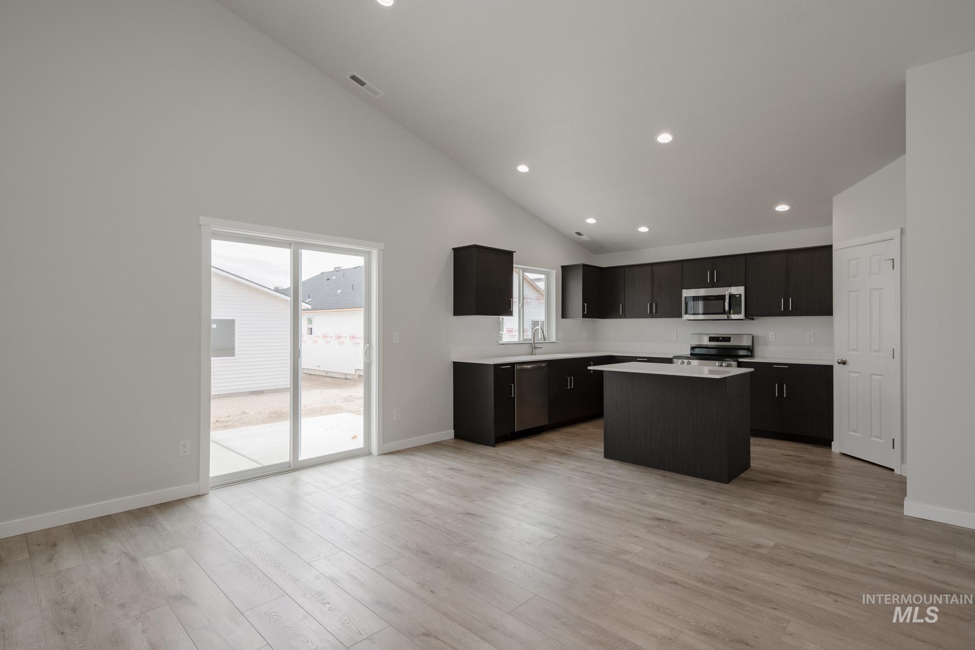 Kitchen featuring a kitchen island, healthy amount of natural light, recessed lighting, light wood-style flooring, and stainless steel appliances