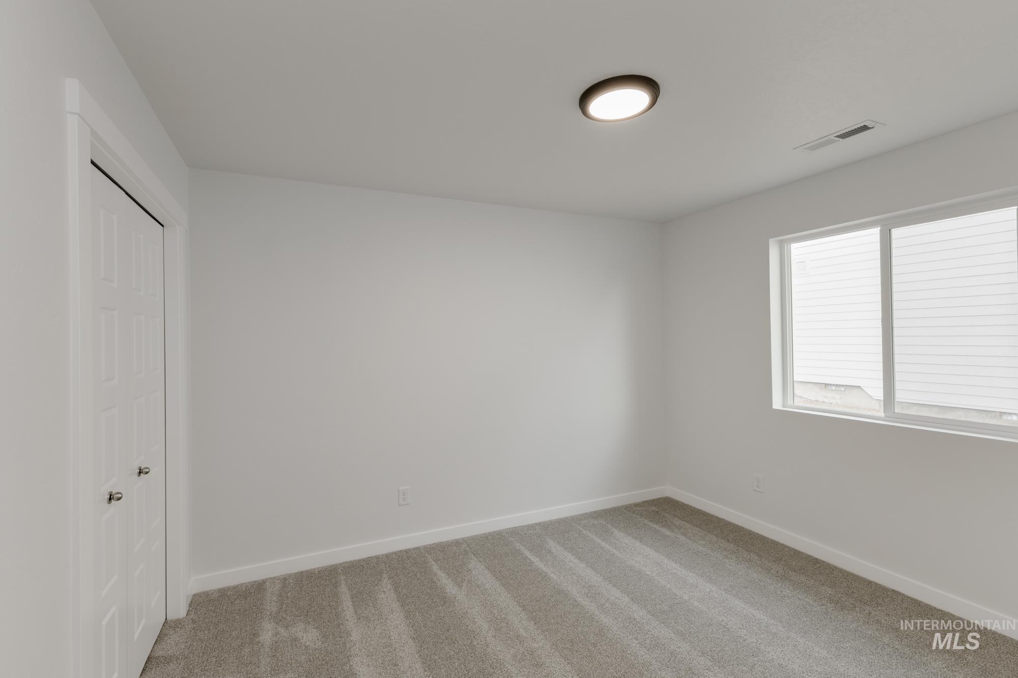 Unfurnished bedroom with light colored carpet and a closet