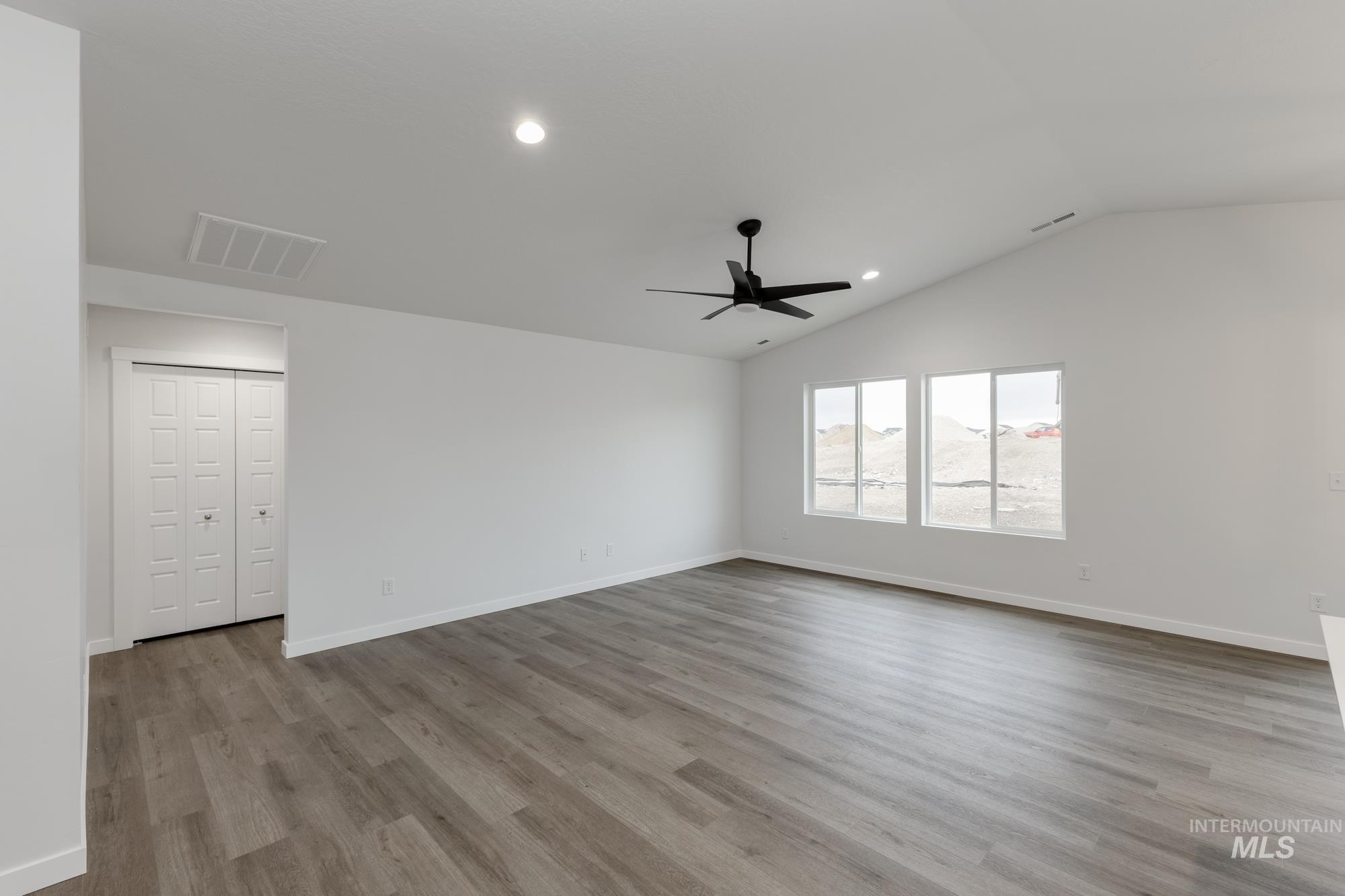 Empty room featuring recessed lighting, vaulted ceiling, light wood-type flooring, and a ceiling fan