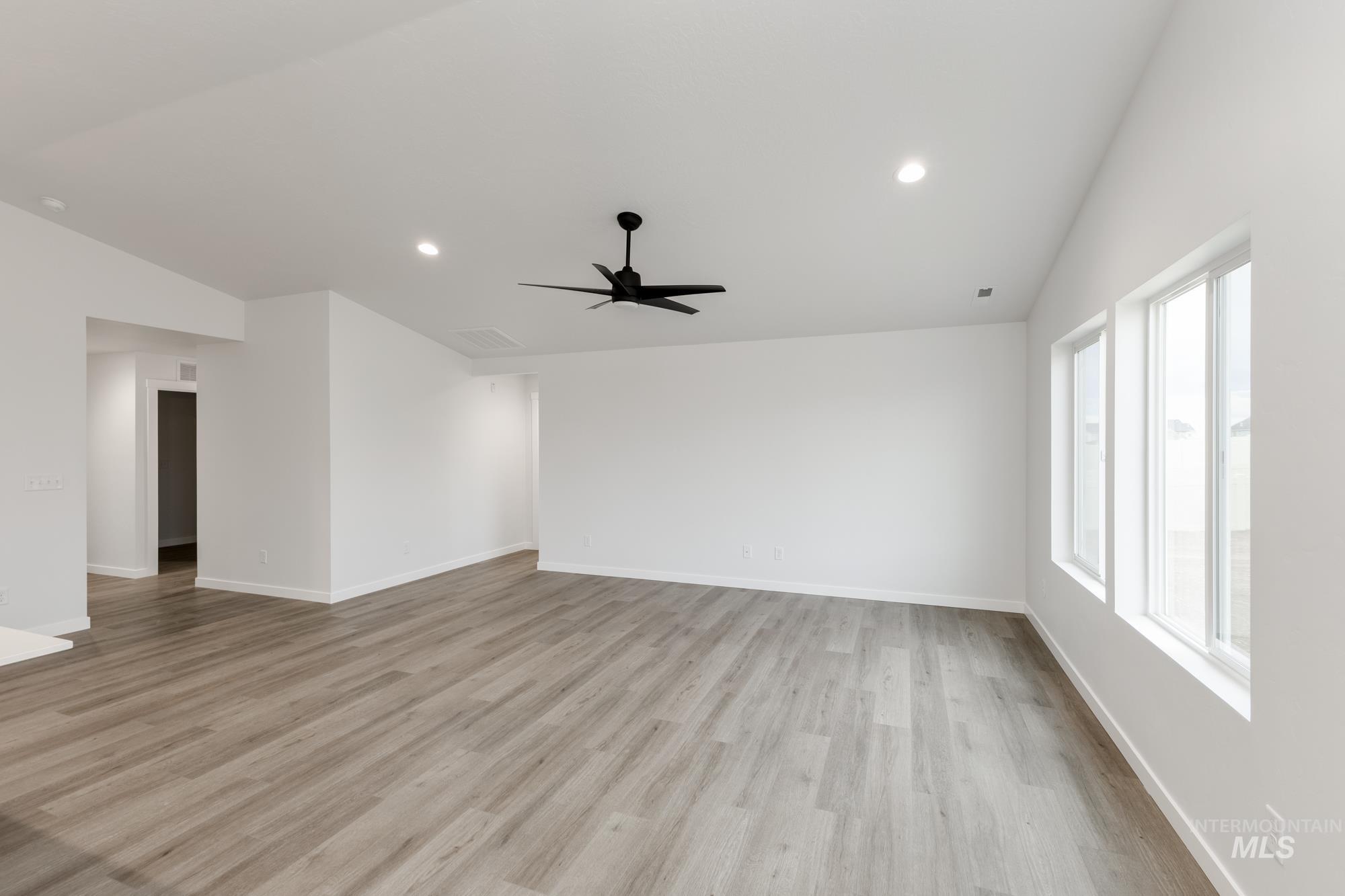 Spare room with lofted ceiling, light wood-style floors, recessed lighting, and a ceiling fan