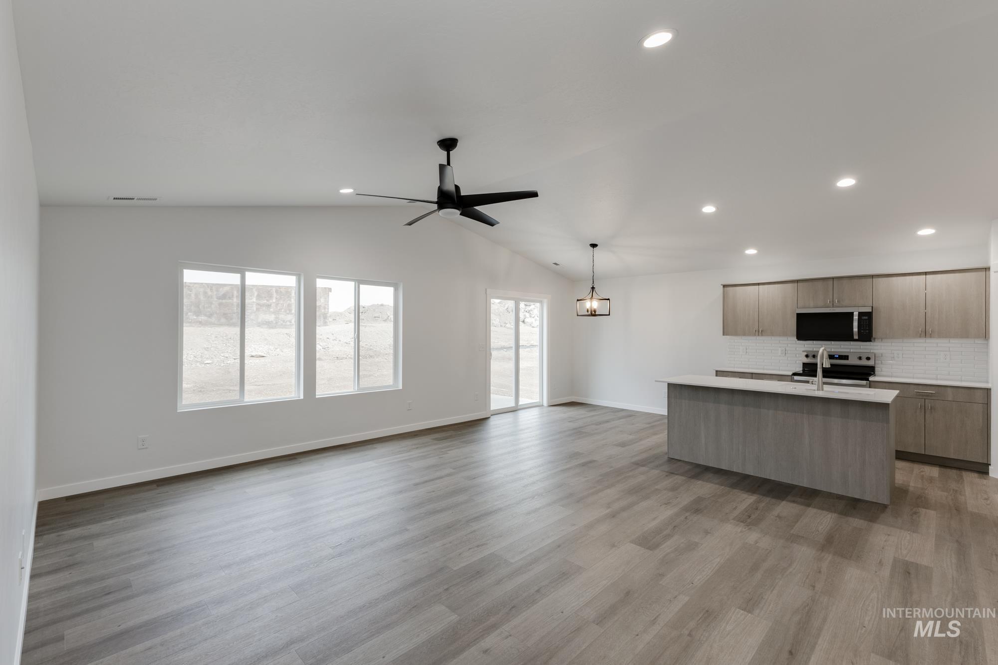 Unfurnished living room featuring recessed lighting, light wood-style floors, ceiling fan, and lofted ceiling