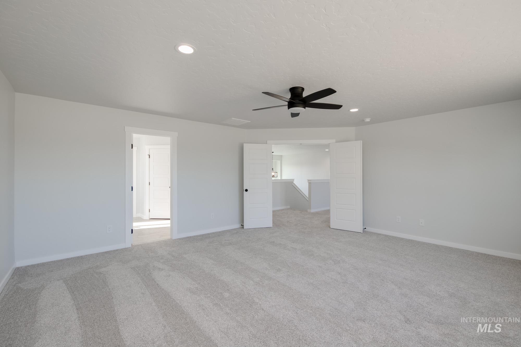Unfurnished bedroom featuring light carpet, recessed lighting, a ceiling fan, and a textured ceiling