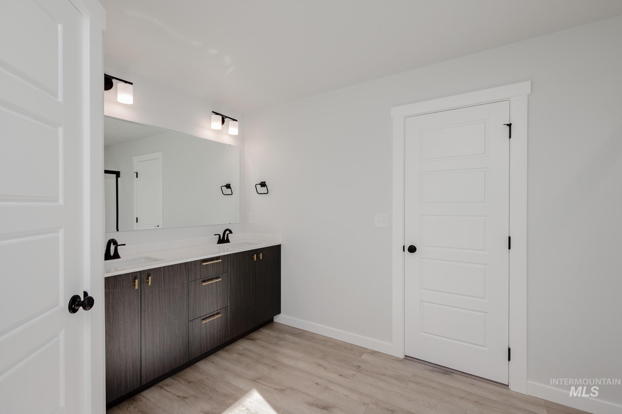 Bathroom featuring double vanity and light wood-style flooring