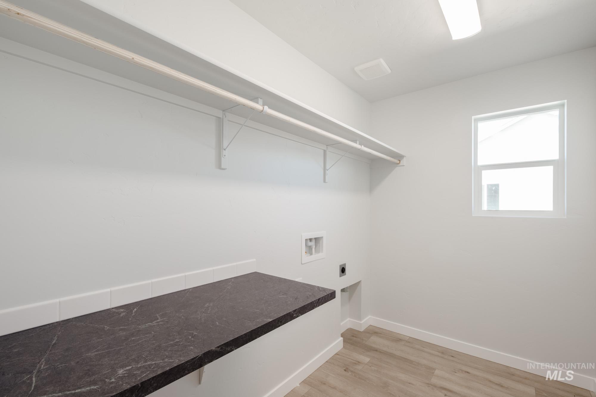 Laundry room with light wood finished floors, hookup for an electric dryer, and washer hookup