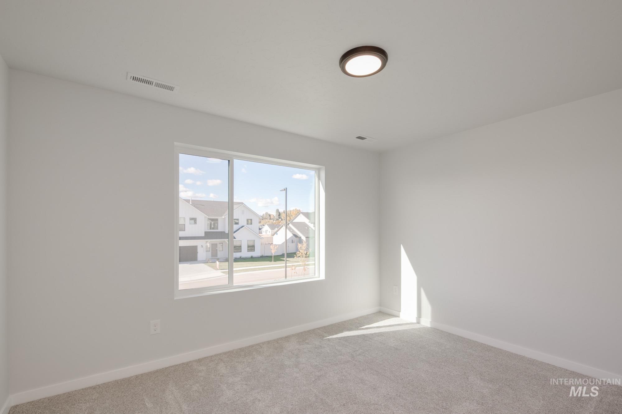 Carpeted empty room with baseboards