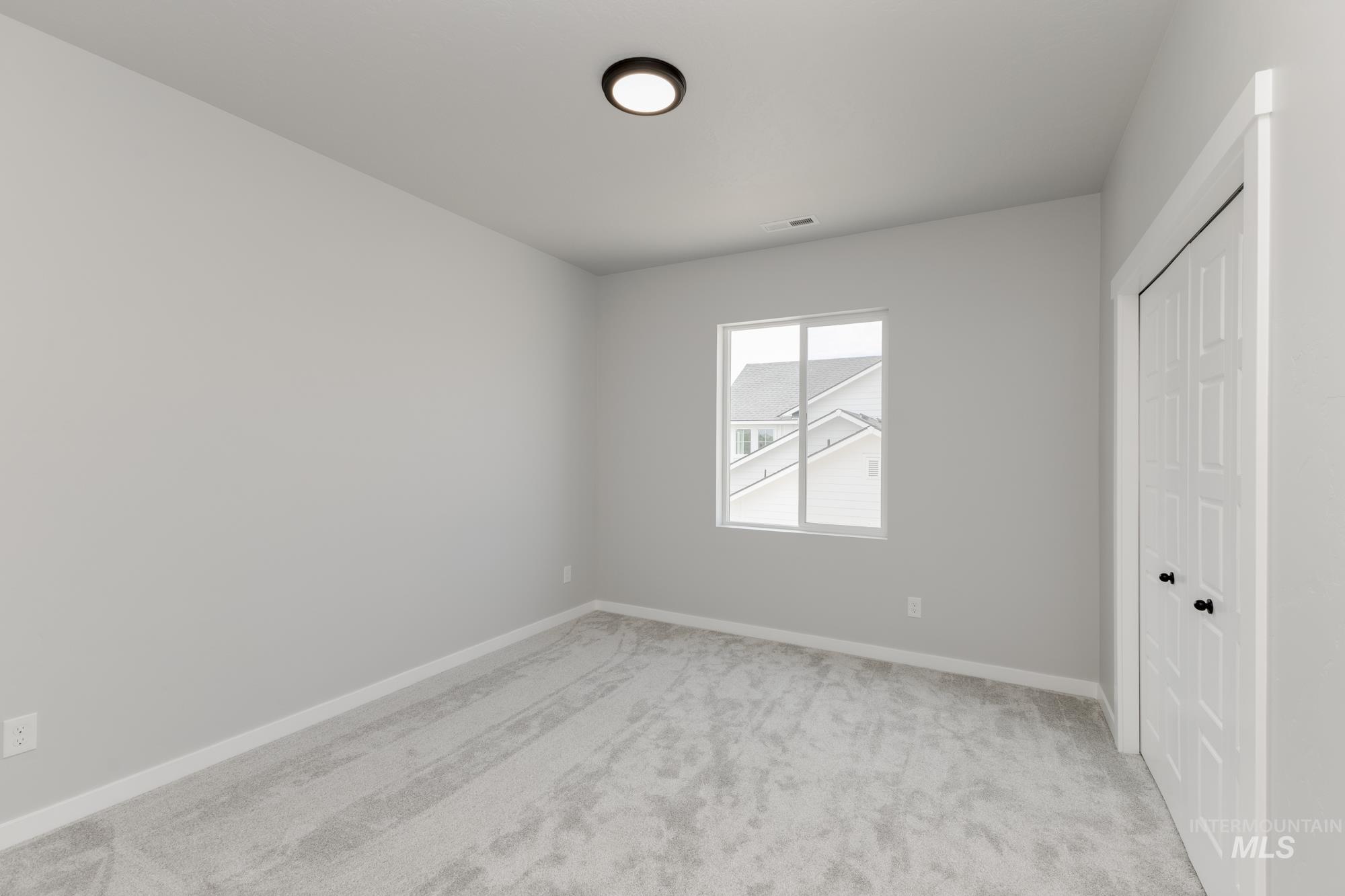 Unfurnished bedroom featuring light colored carpet and a closet