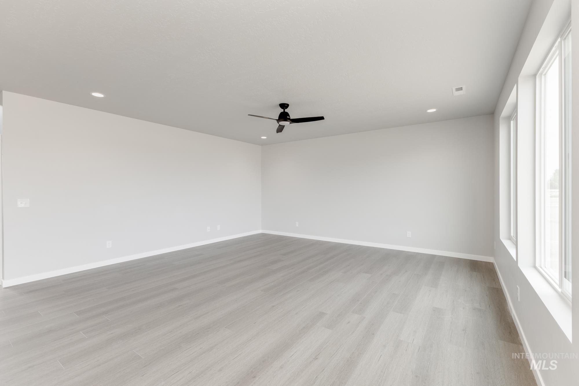 Unfurnished room featuring light wood-type flooring, ceiling fan, and recessed lighting