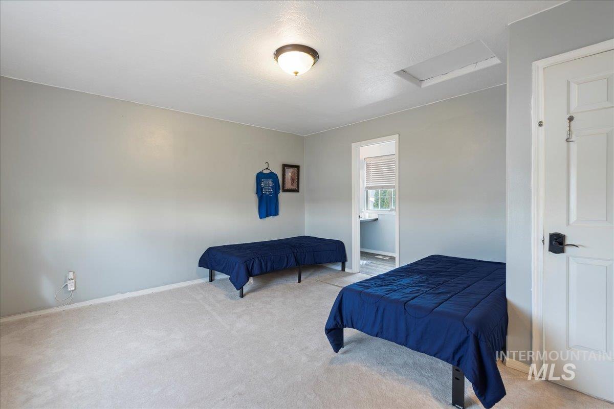Bedroom featuring attic access and carpet flooring