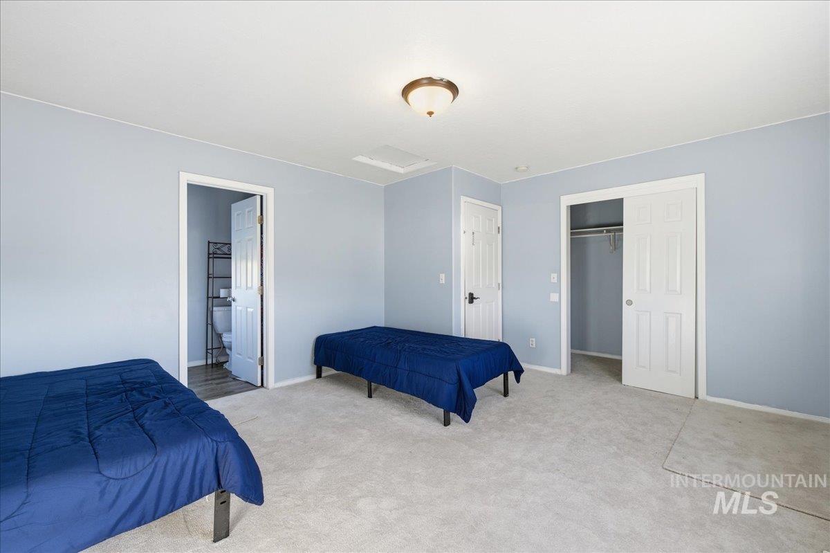 Bedroom featuring a closet, carpet flooring, and ensuite bath