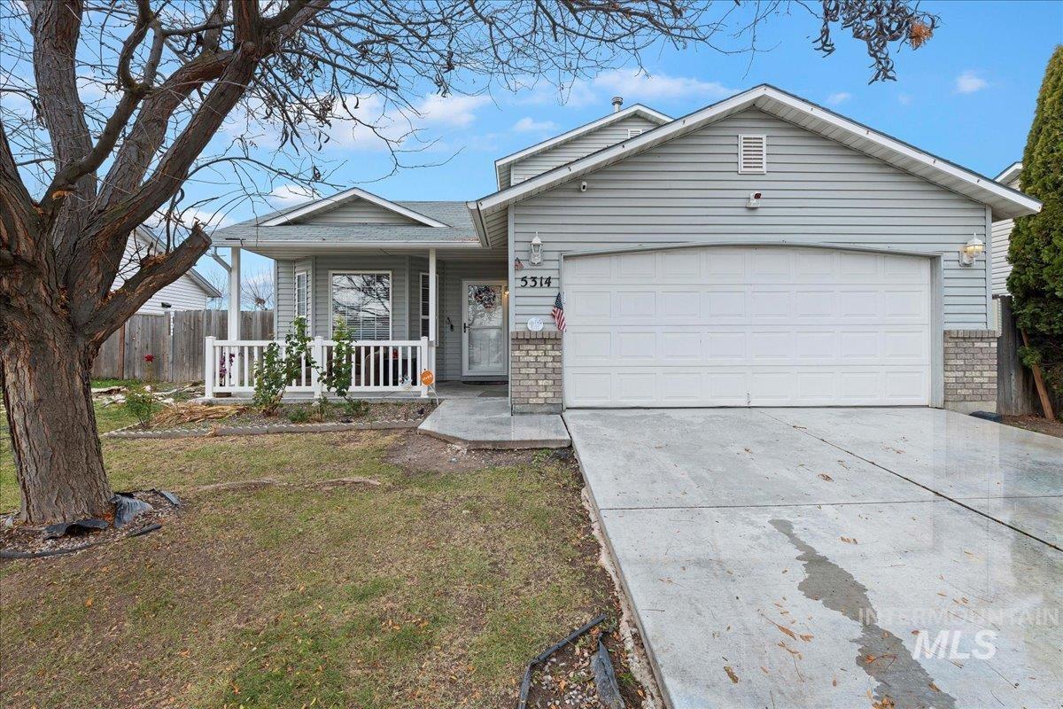 Ranch-style home with covered porch, driveway, brick siding, and an attached garage
