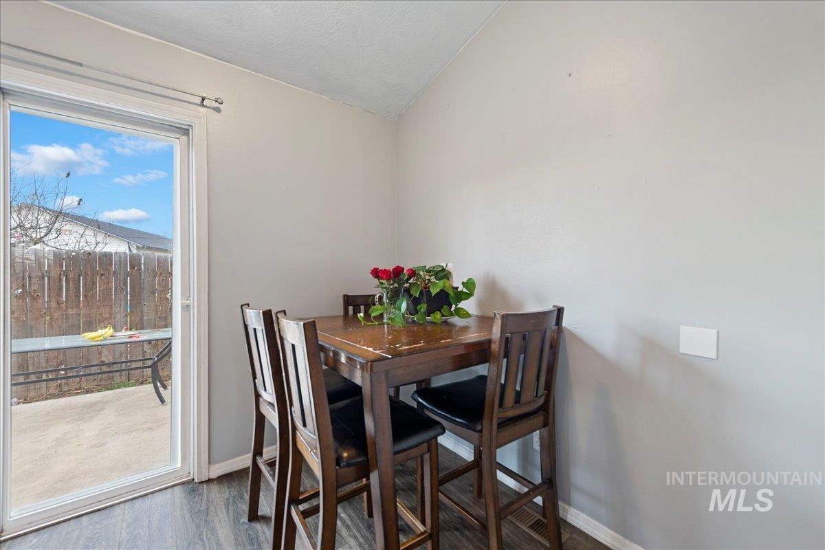 Dining room featuring wood finished floors and vaulted ceiling