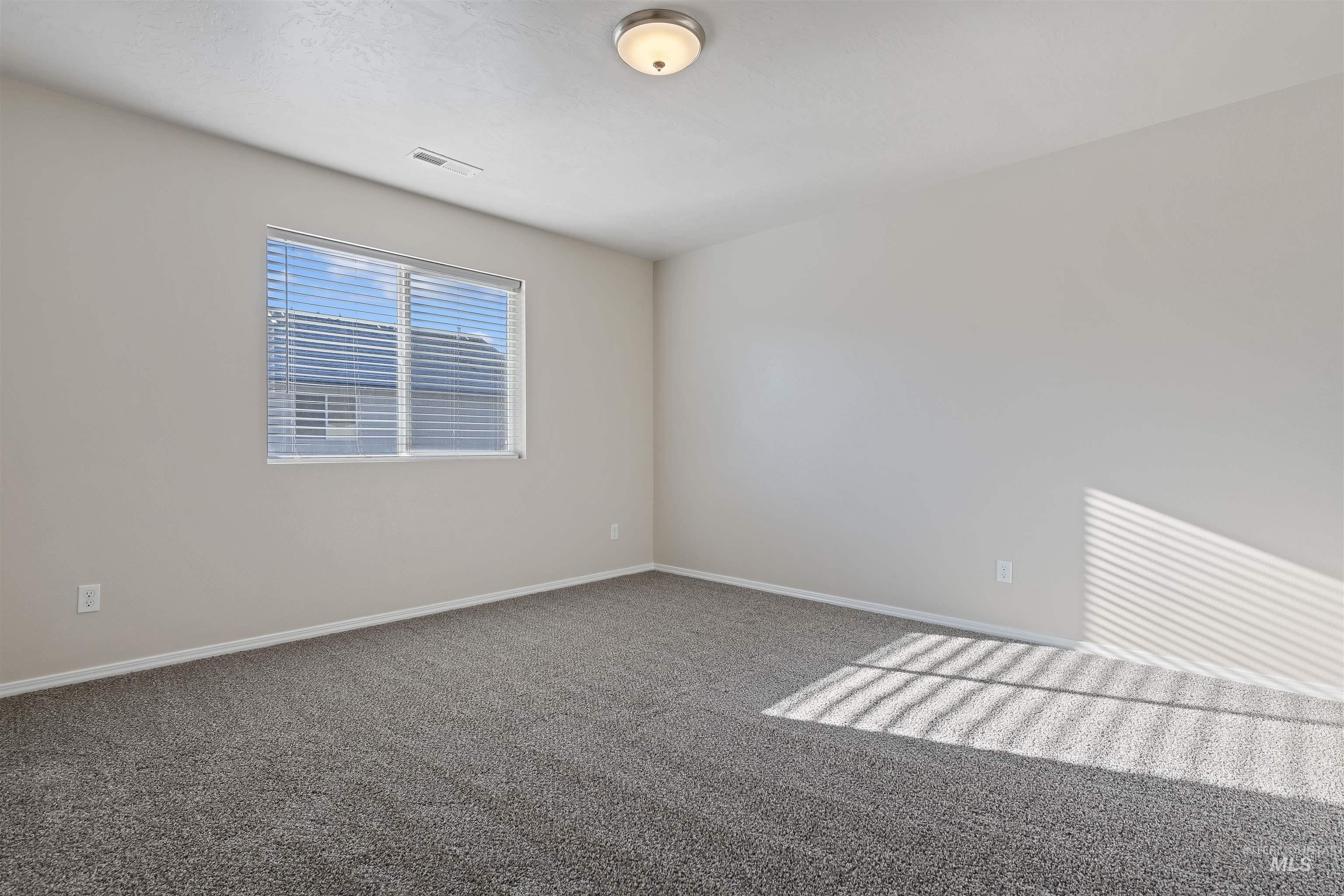 Spare room with carpet and baseboards