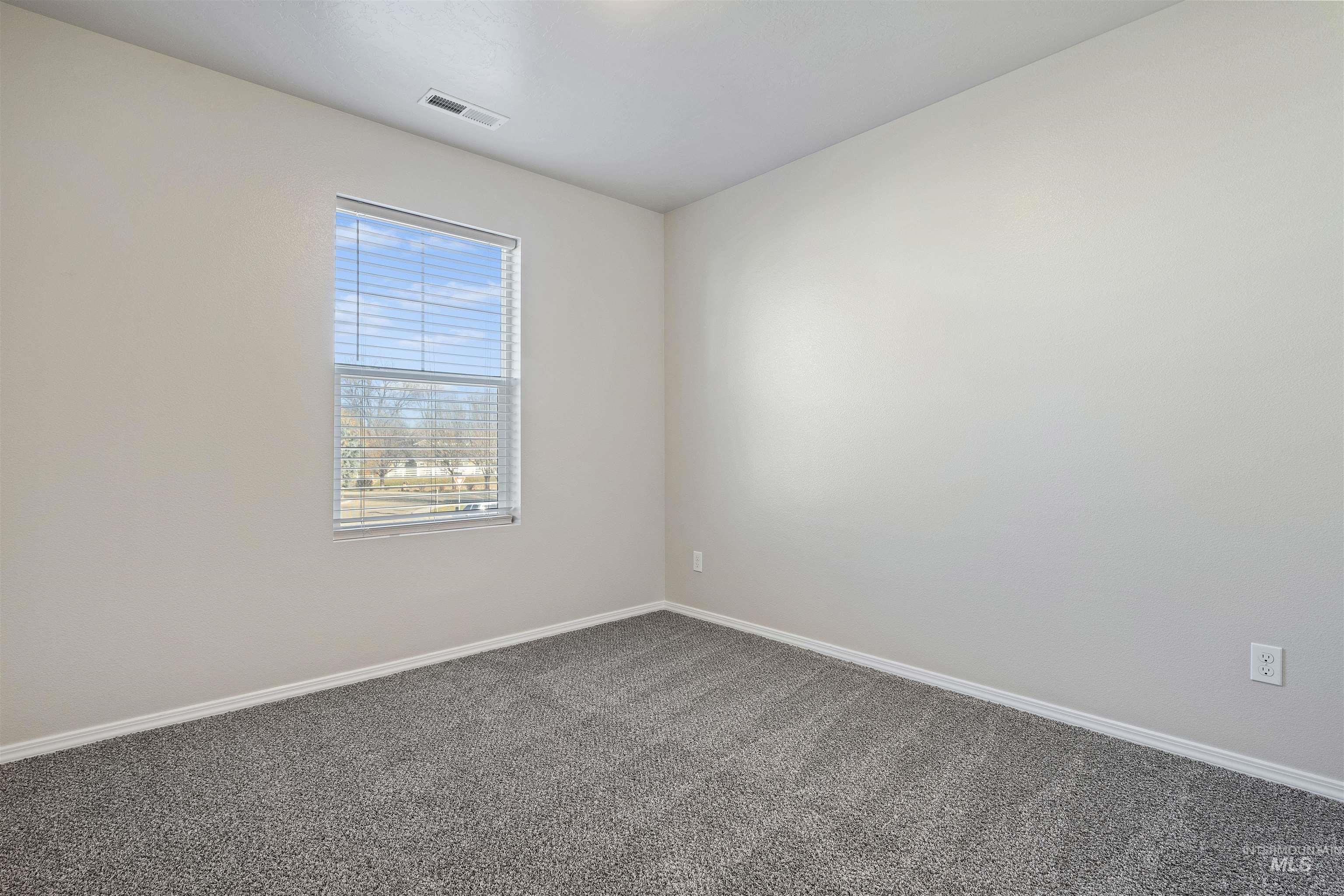 Carpeted empty room featuring baseboards