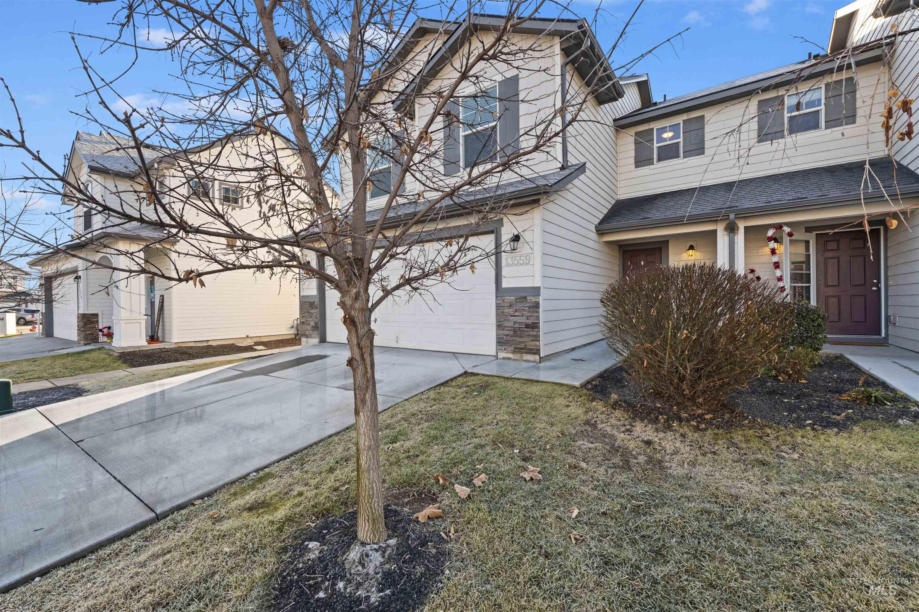 Traditional-style house with driveway, a garage, and stone siding