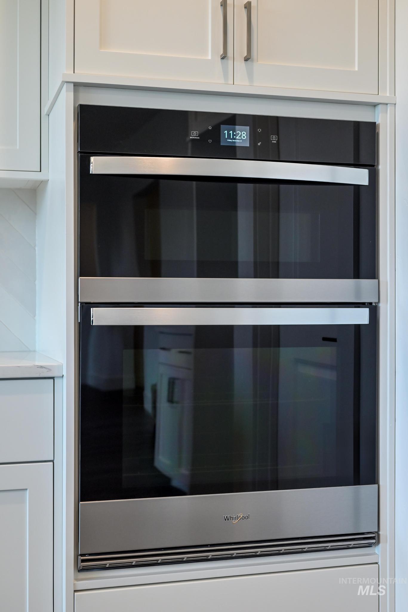 Kitchen view of white cabinets and stainless steel double oven