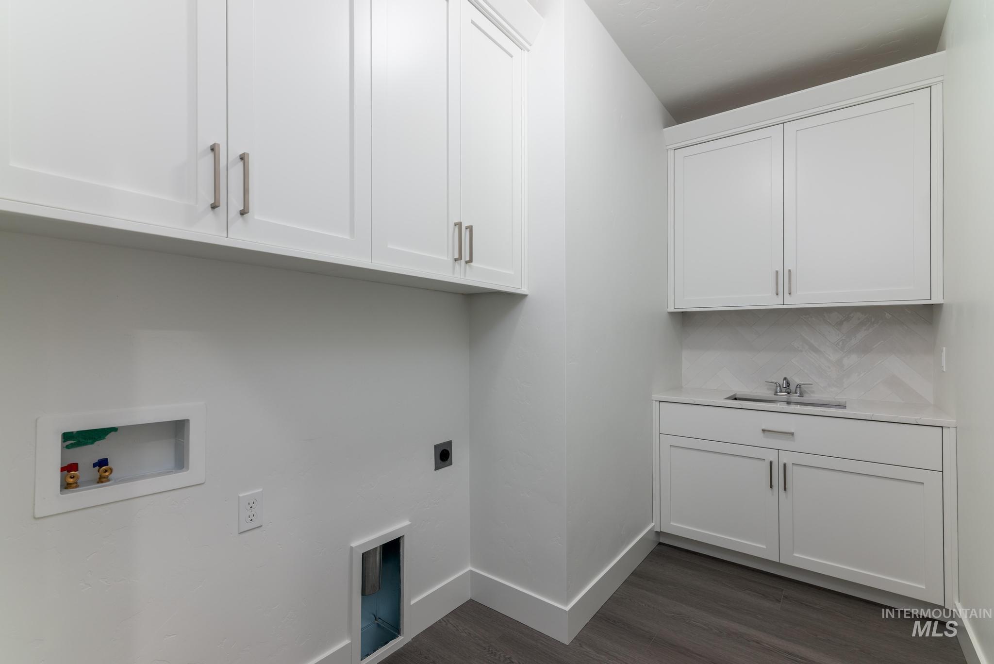Laundry room featuring cabinet space, dark wood-type flooring, hookup for an electric dryer, and washer hookup